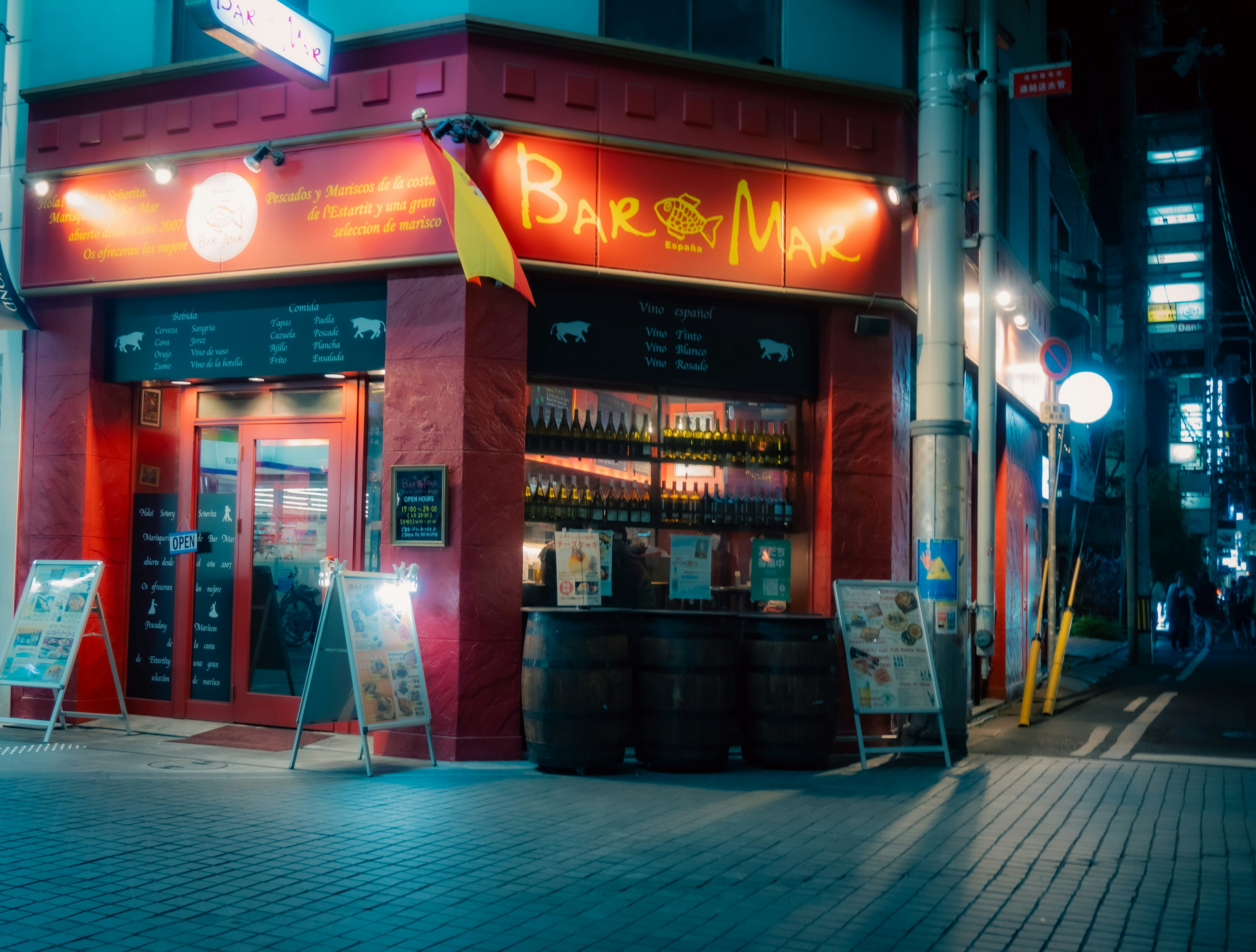 Exterior of a bar and wine shop illuminated at night