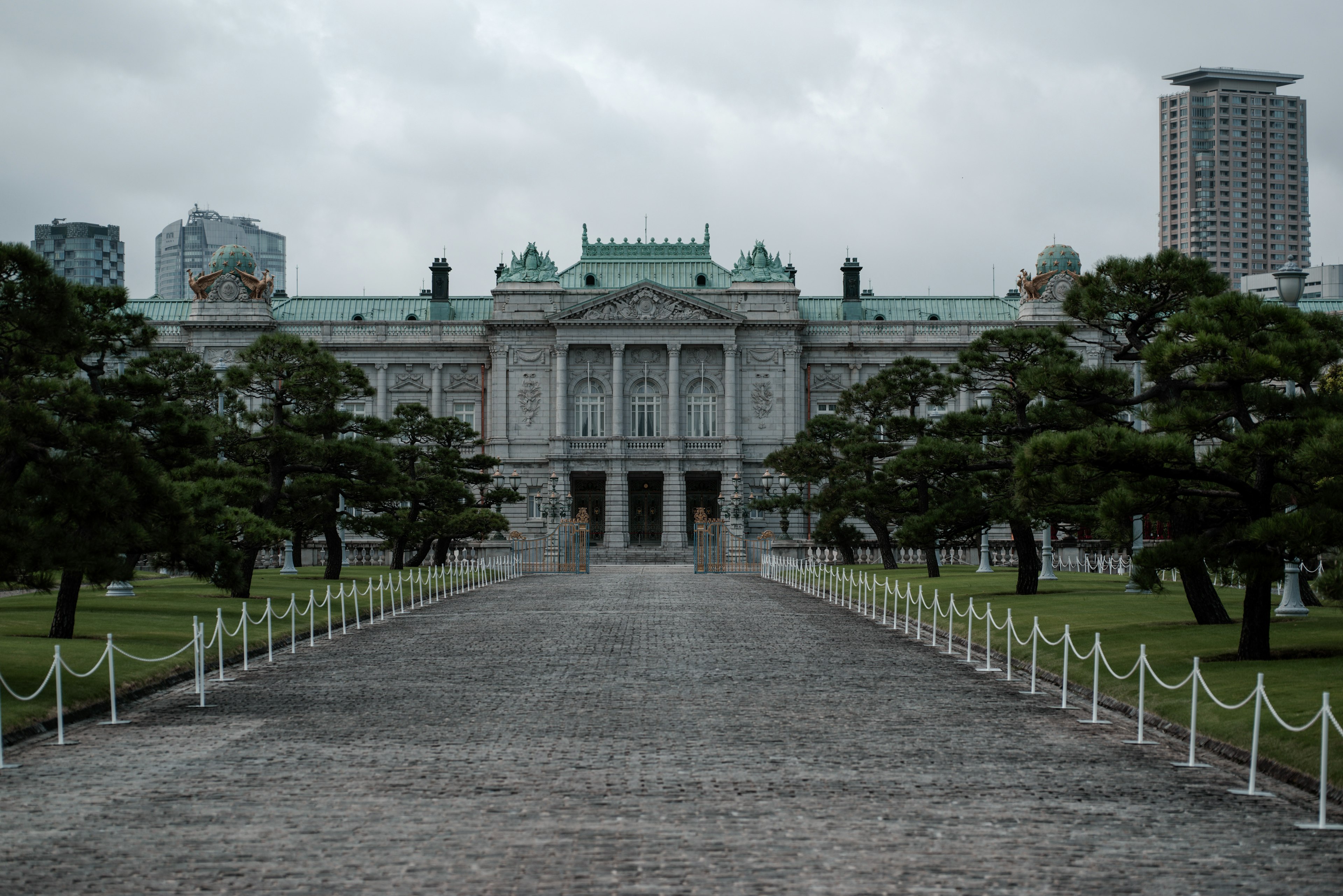 大きな建物と緑の木々がある公園の前景