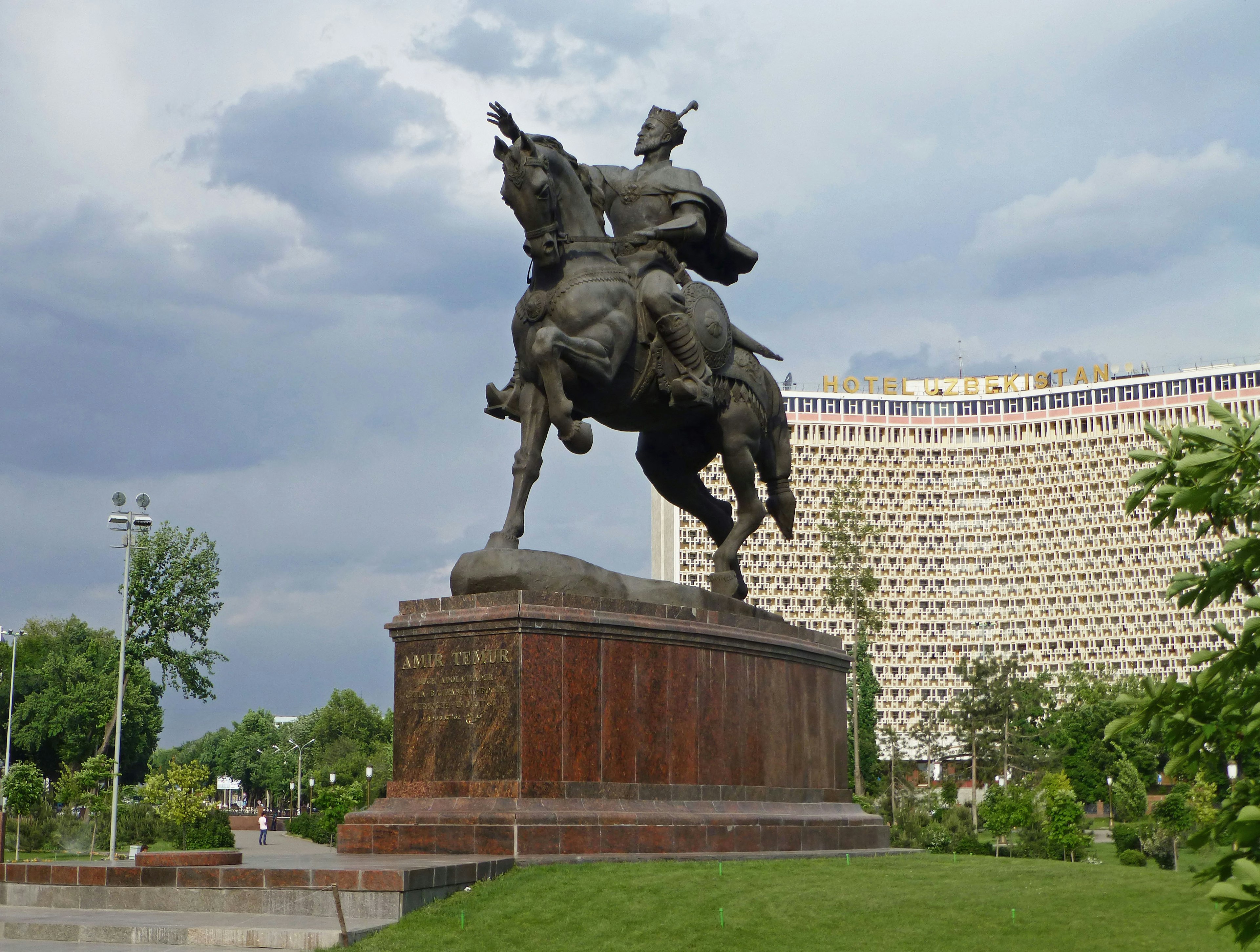 Equestrian statue with a lush green park in the background