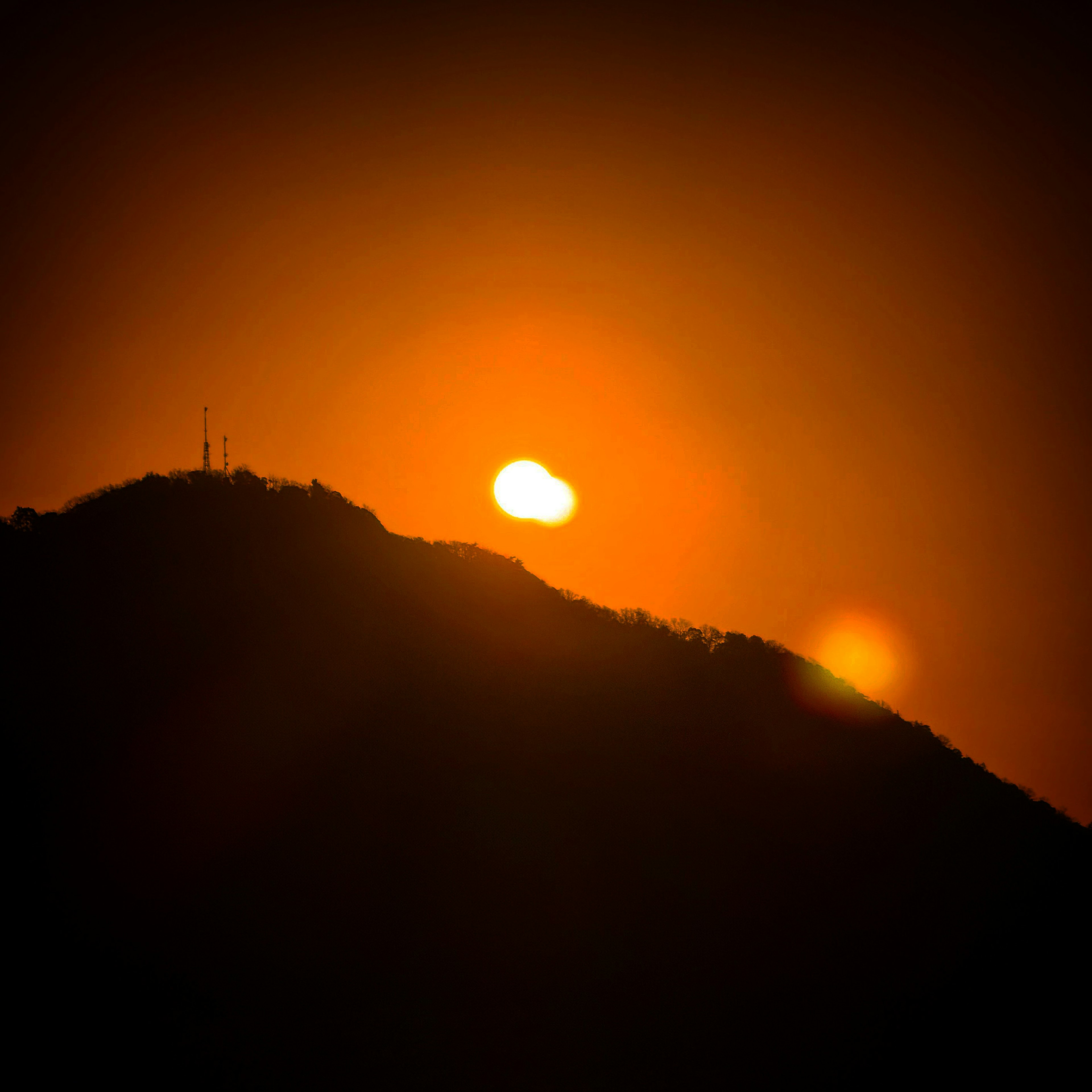 Hermoso paisaje con el atardecer iluminando la silueta de la montaña