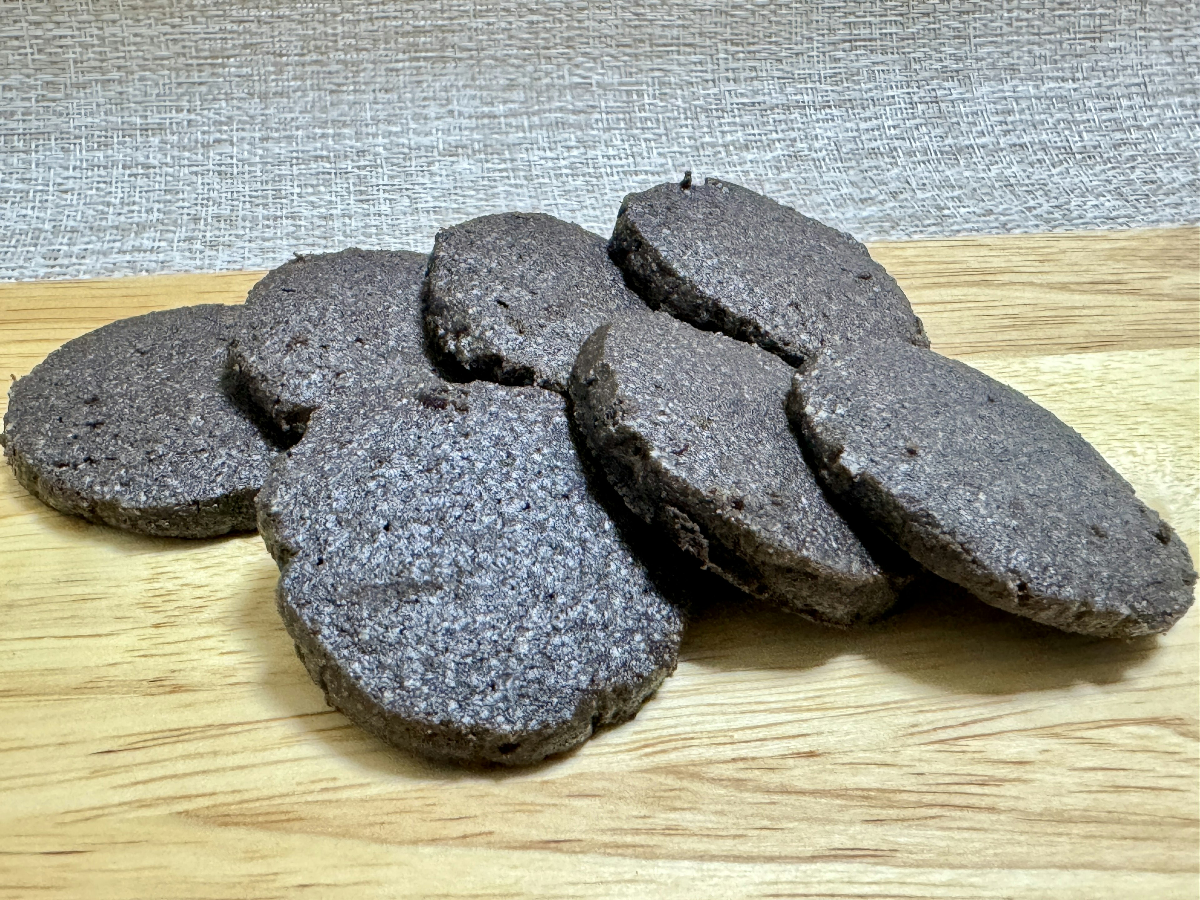 Freshly baked chocolate cookies arranged on a wooden plate