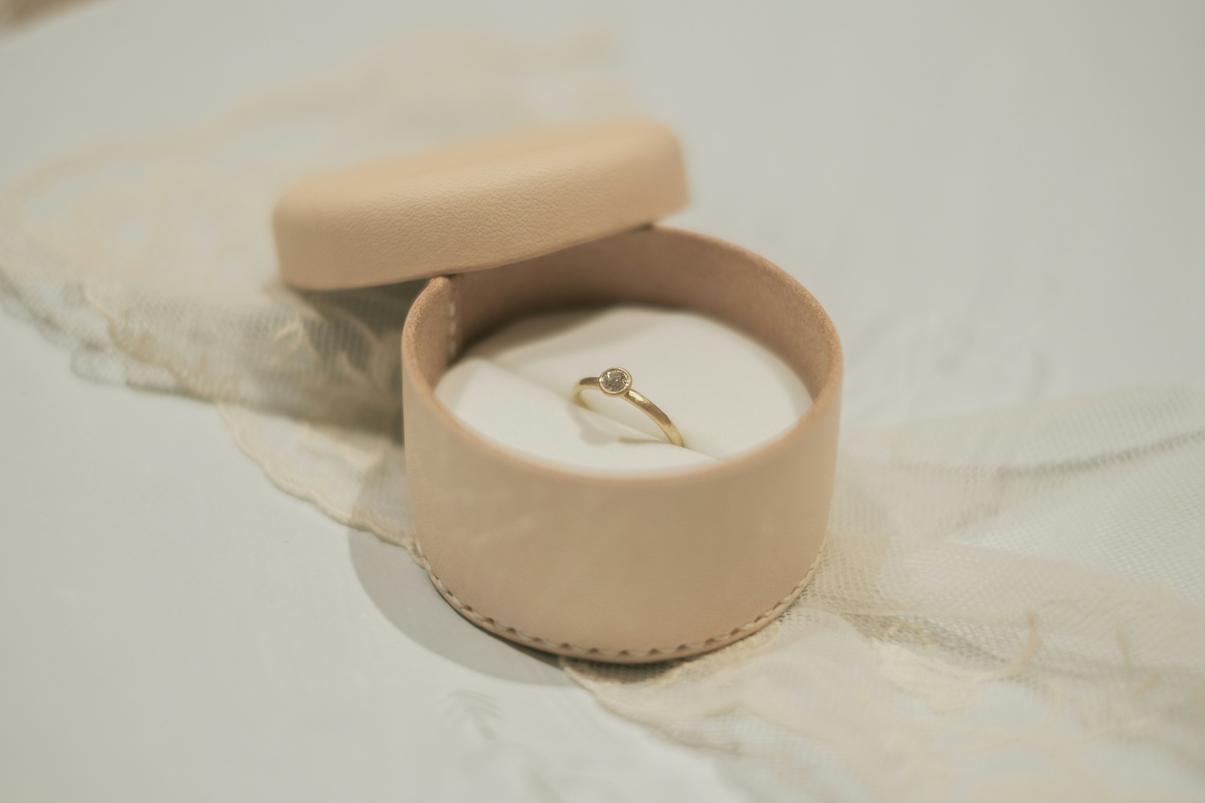 Boîte à bijoux beige avec une bague à l'intérieur