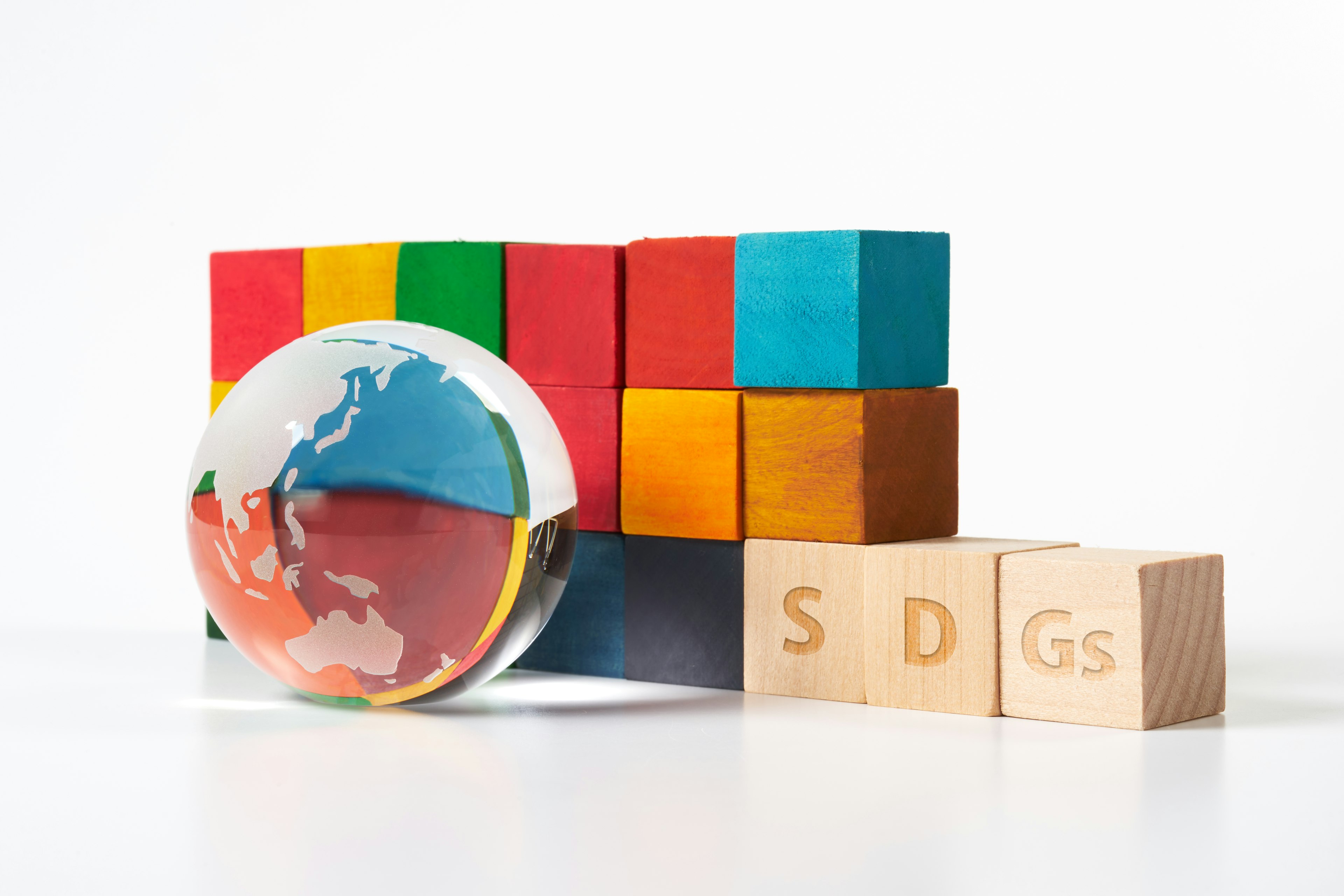 Bunte Blöcke und ein Globus mit enthaltenen SDGs-Blöcken