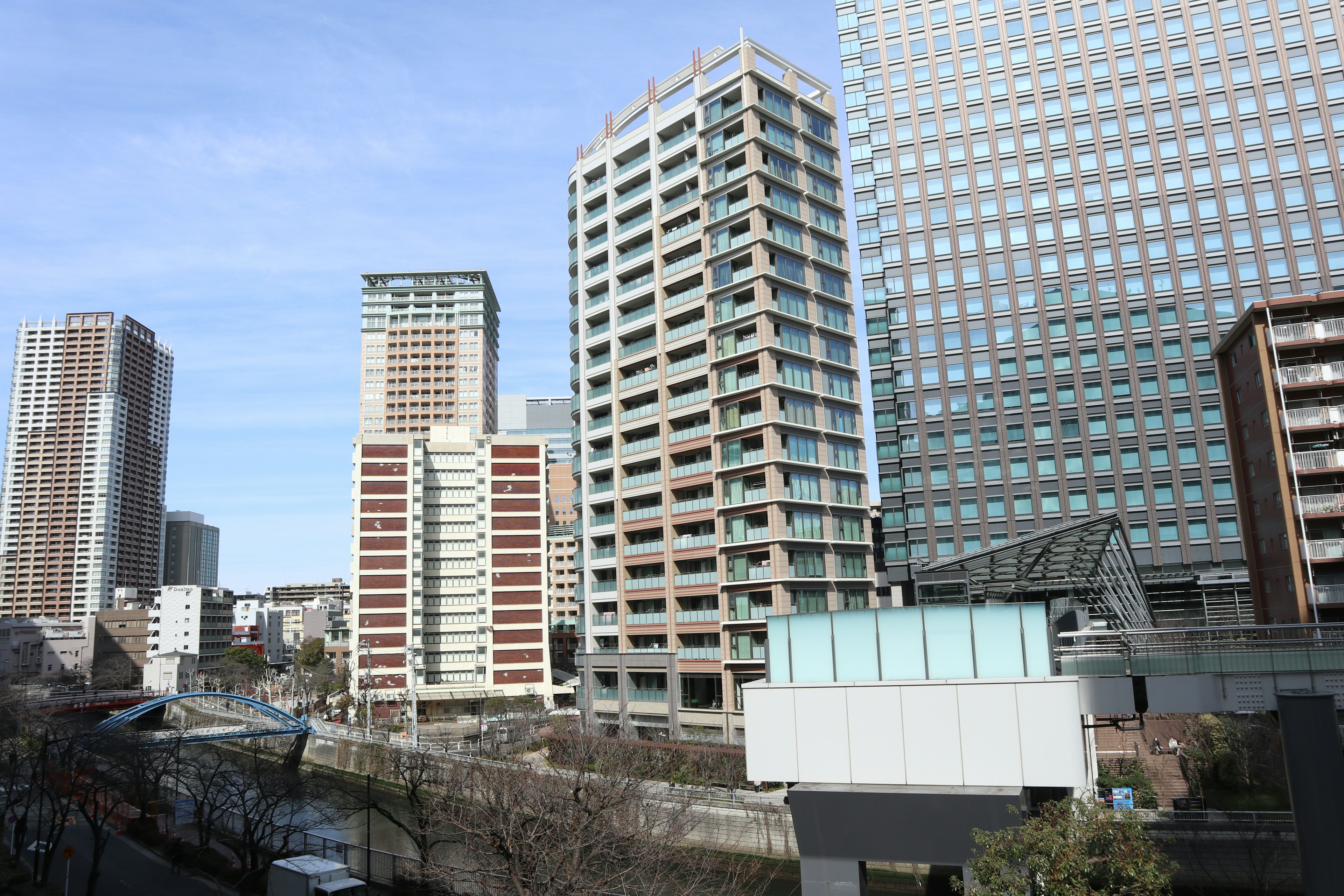 Cityscape featuring a mix of high-rise and low-rise buildings under a clear blue sky