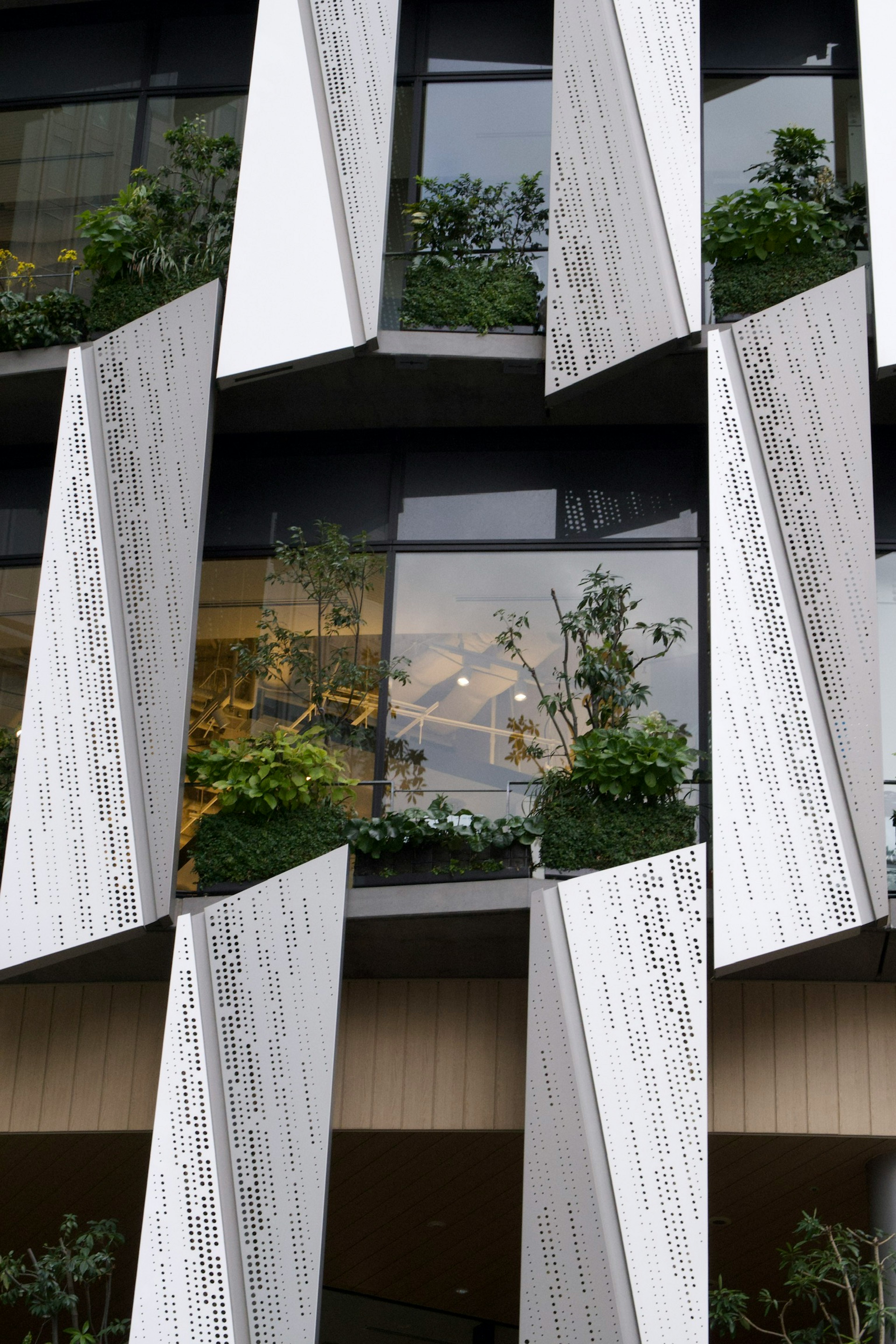 Unique architectural design featuring angled panels with greenery in front of windows