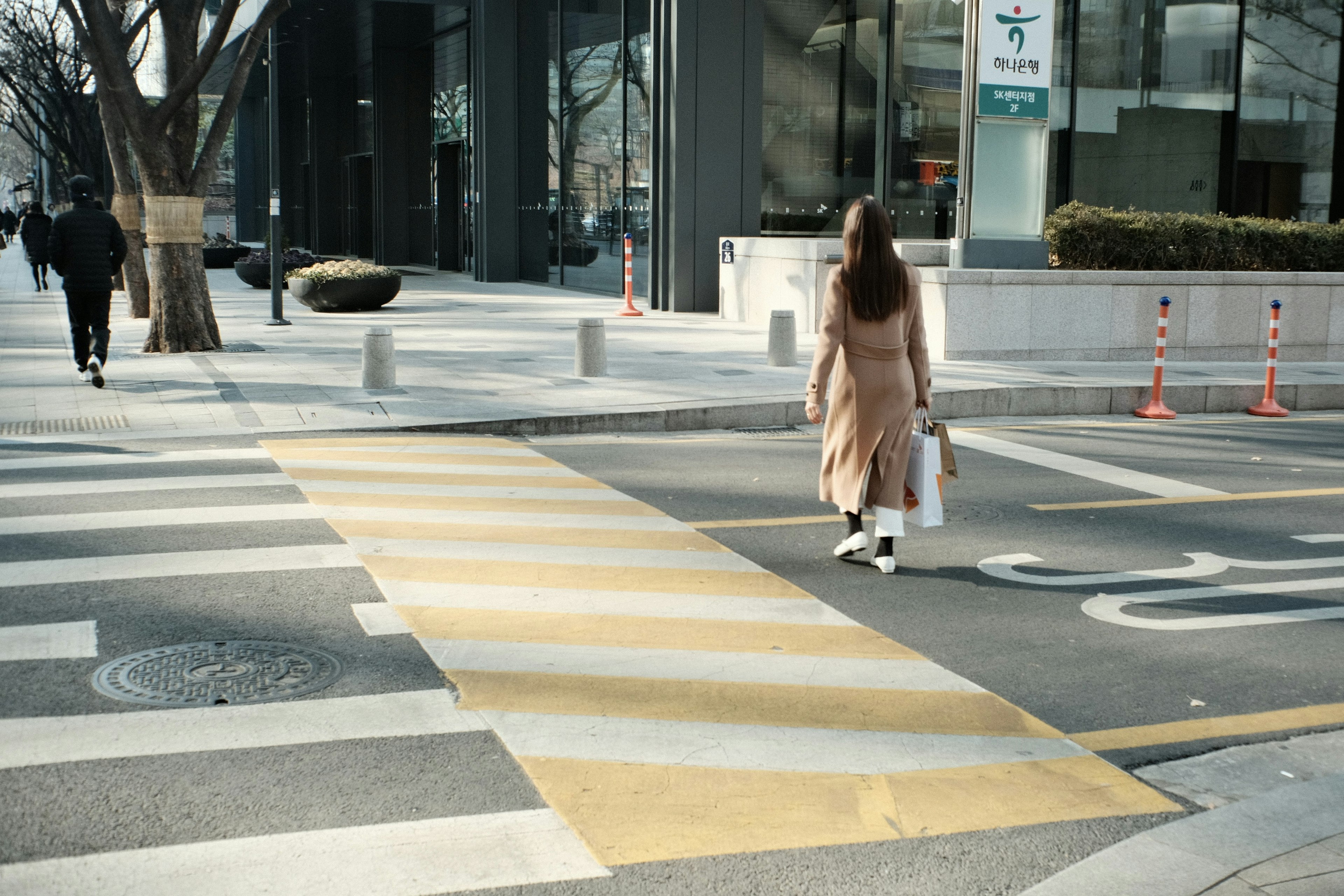 女性が横断歩道を渡る都市の風景