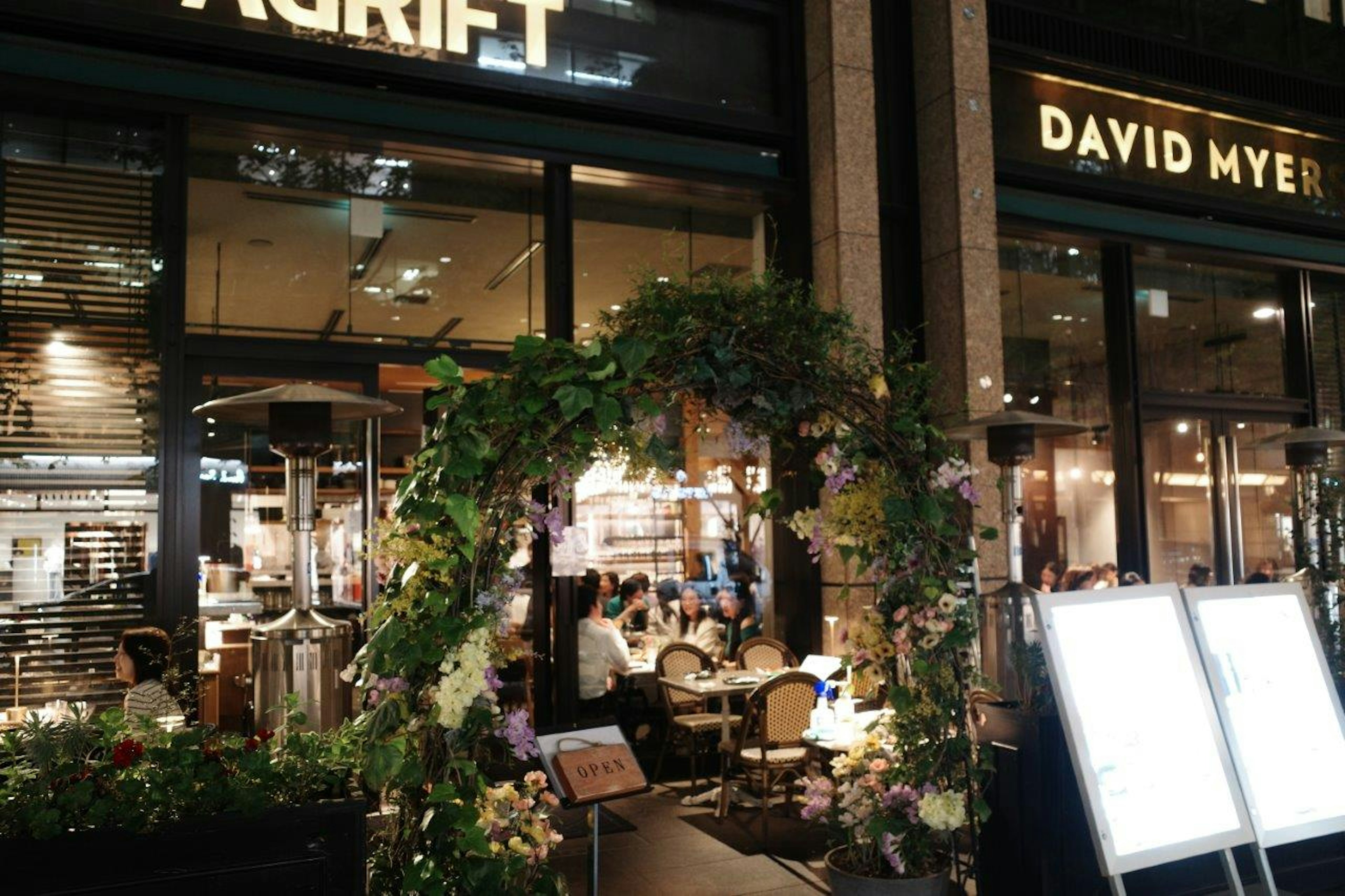 Exterior view of a dining area with a flower-decorated arch