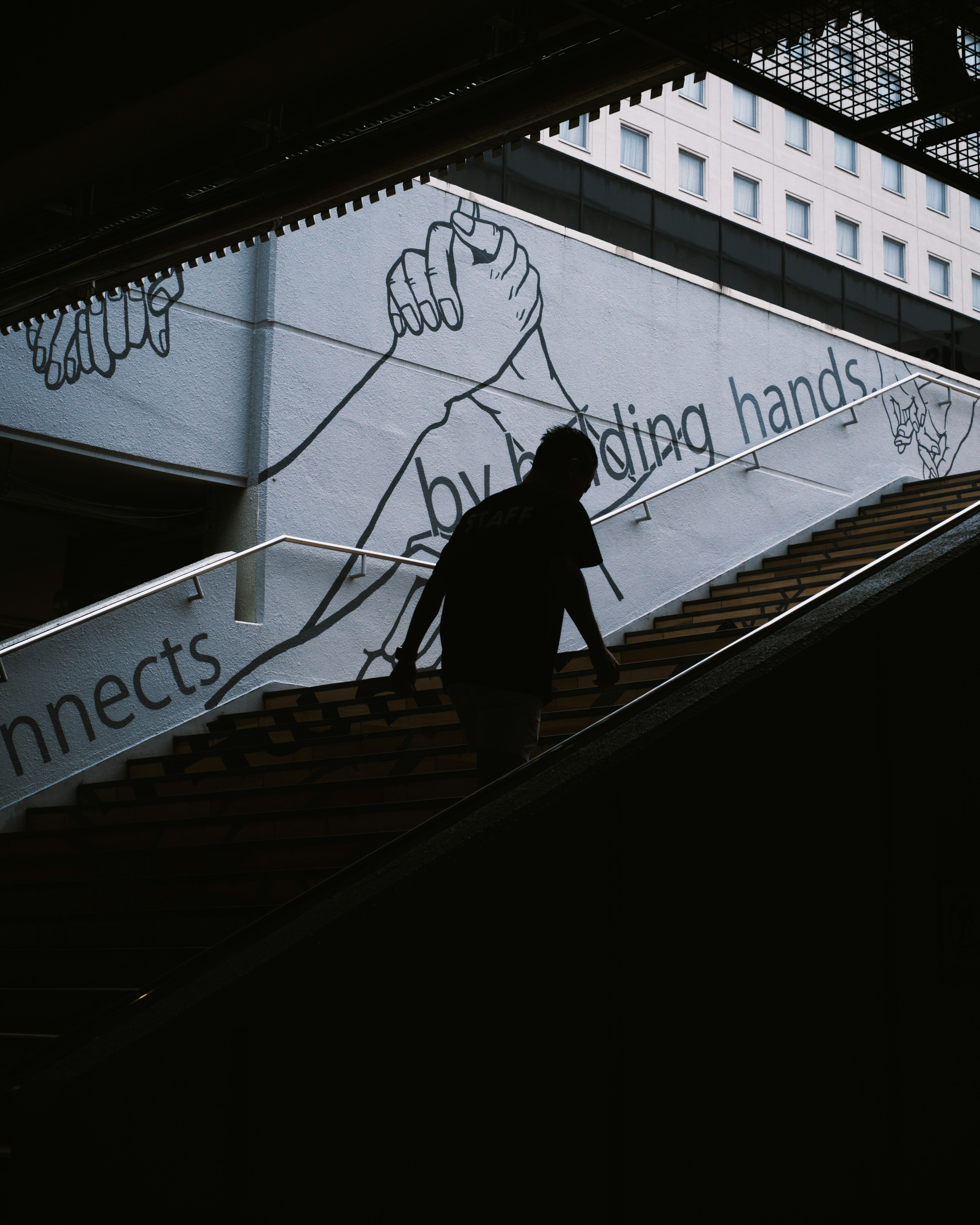 Silhouette einer Person, die Treppen hinuntergeht mit grafischer Kunst im Hintergrund