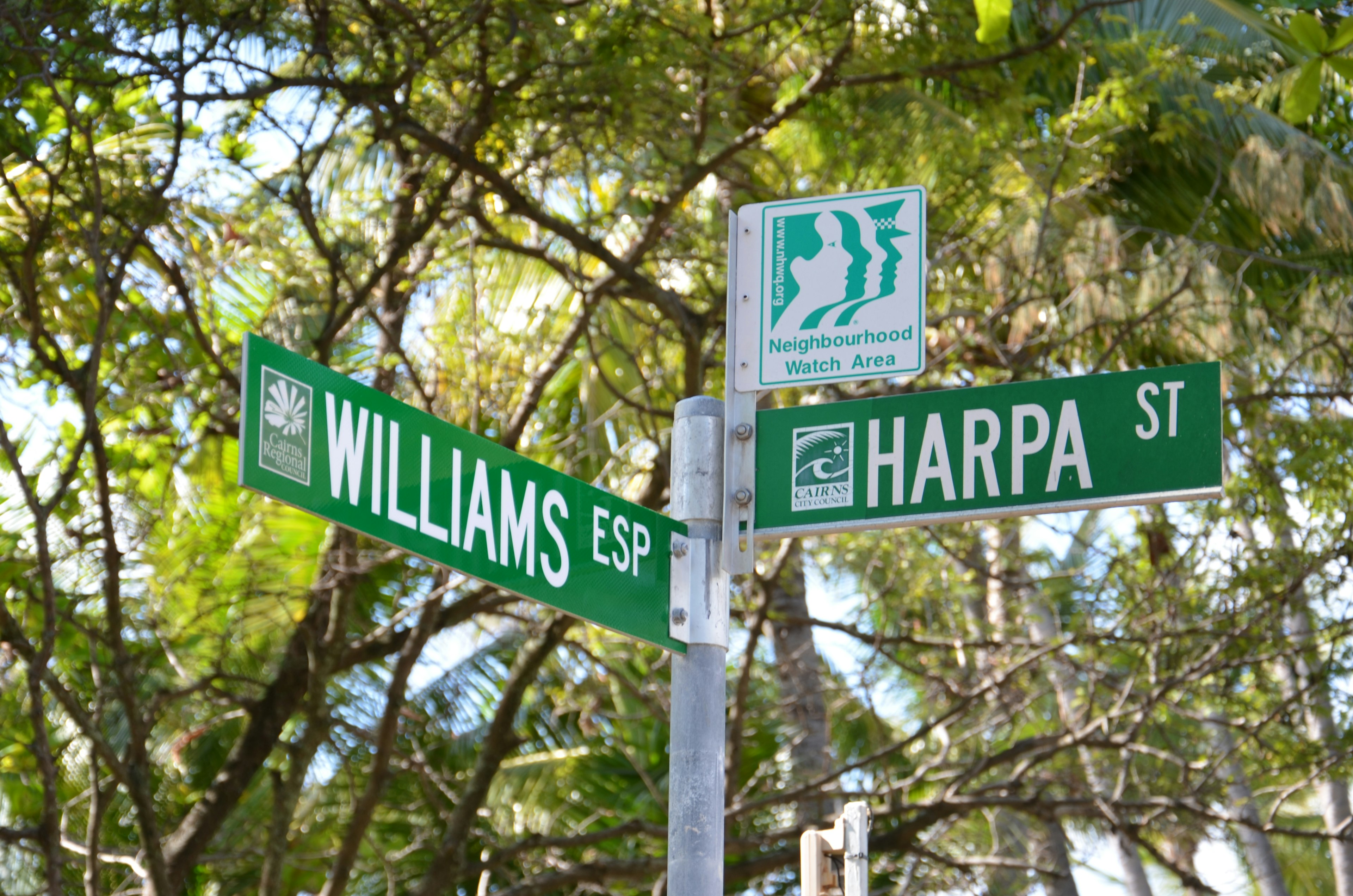 Papan nama jalan di persimpangan Williams Street dan Harpa Street dengan latar belakang hijau dan teks putih