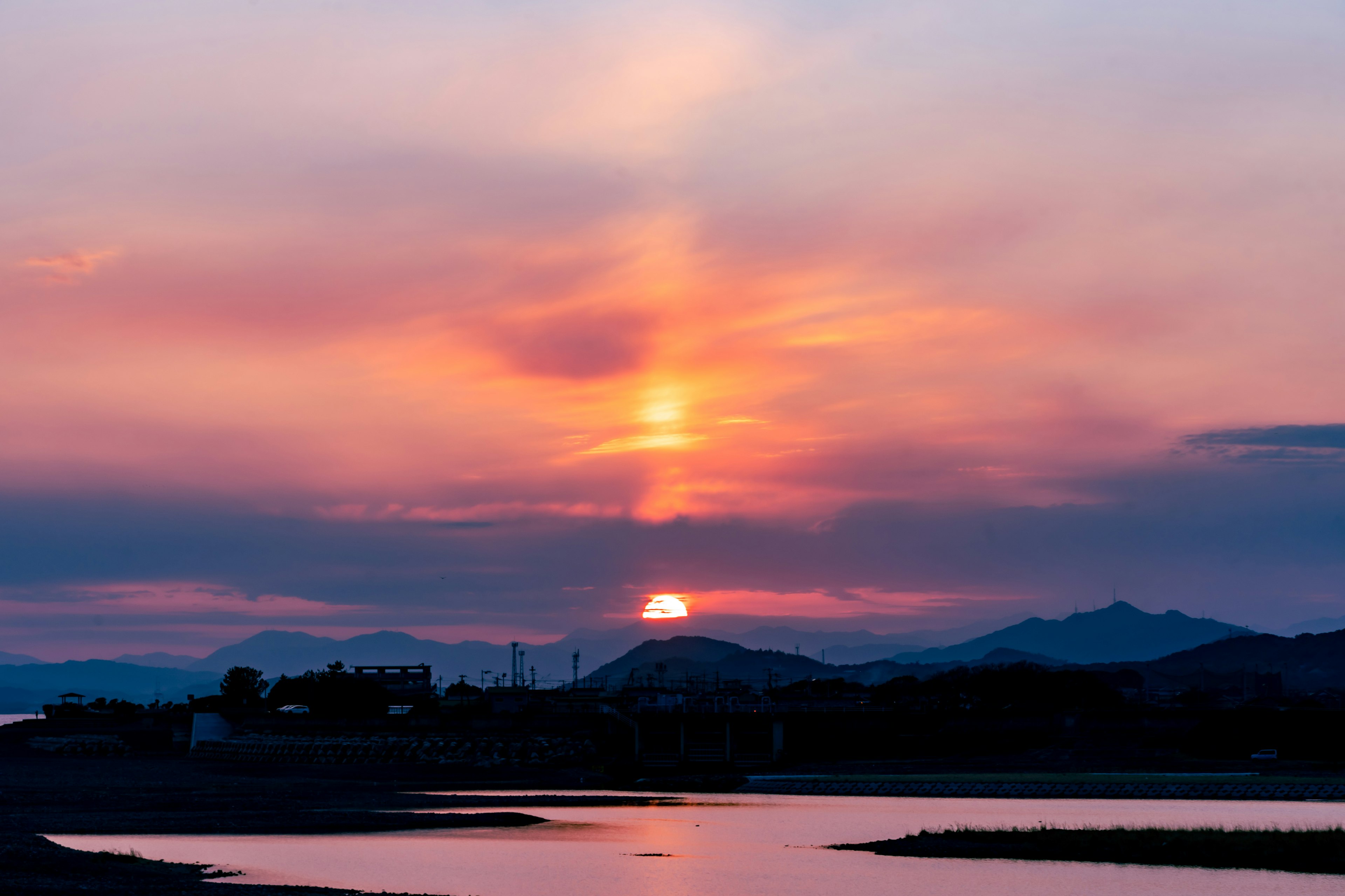 夕日が美しい紫とオレンジの空に沈む風景