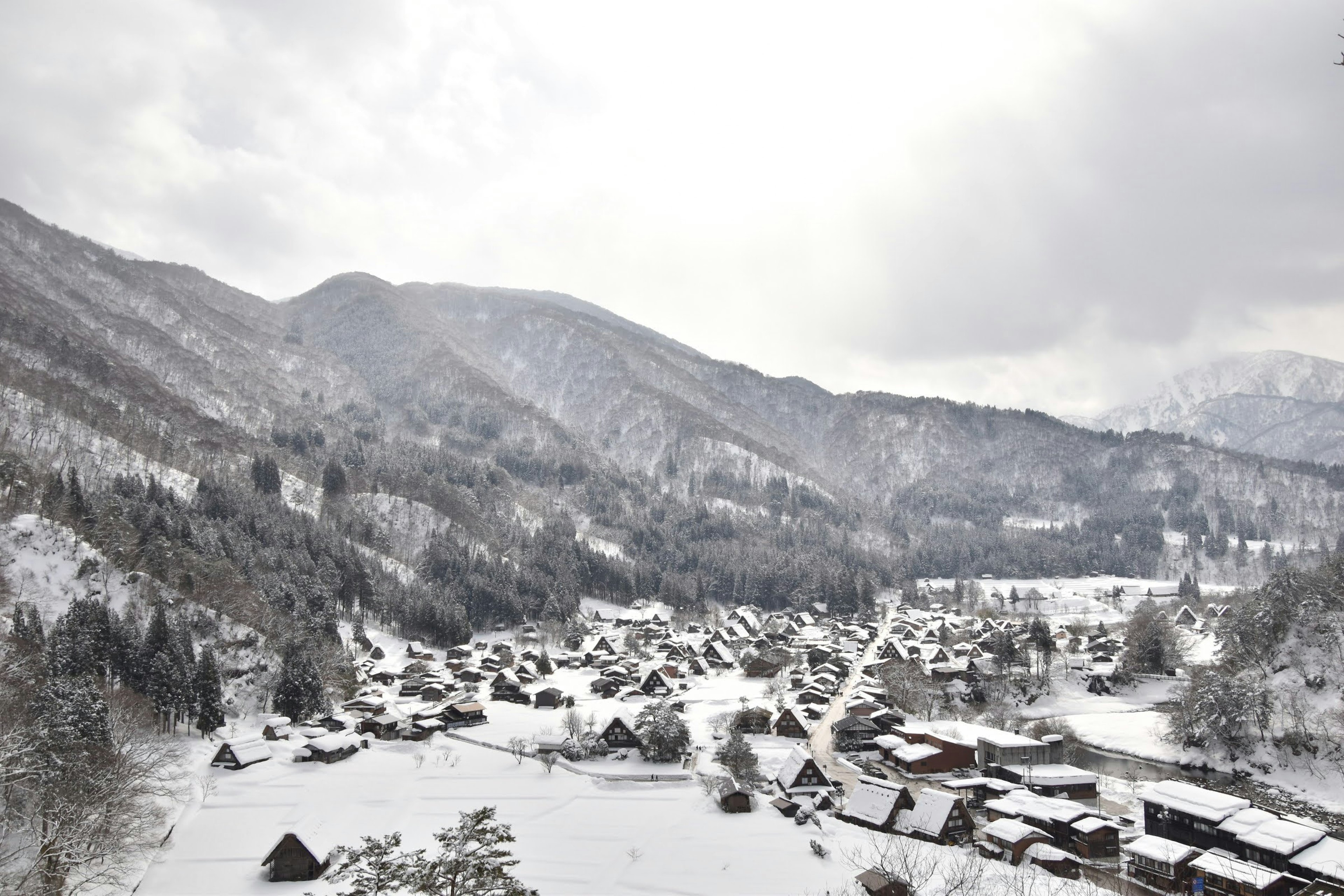 Paesaggio di un villaggio di montagna coperto di neve con nuvole bianche e paesaggio innevato