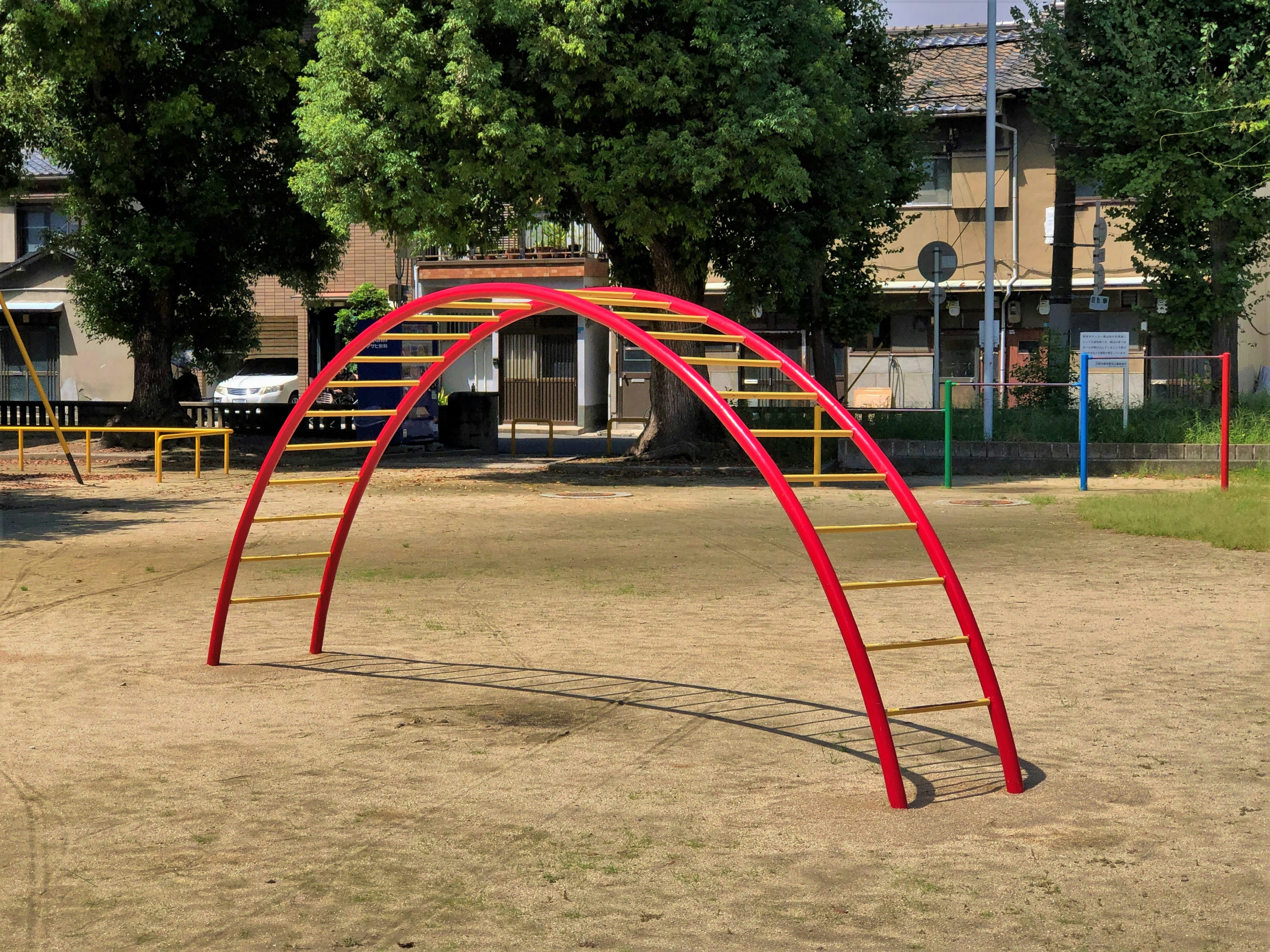 Red playground equipment in a sandy park