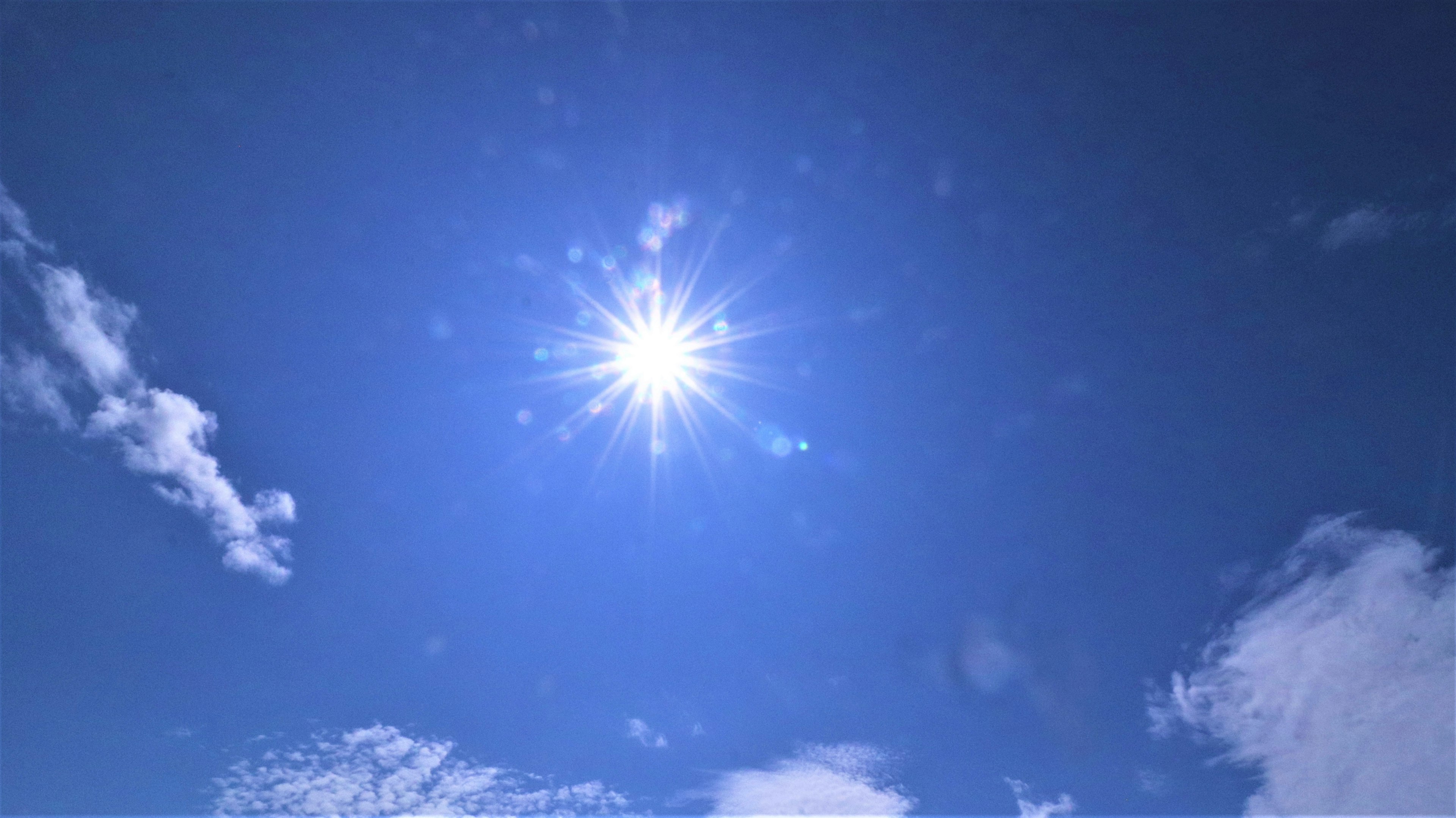 Helle Sonne scheint in einem klaren blauen Himmel mit weißen Wolken