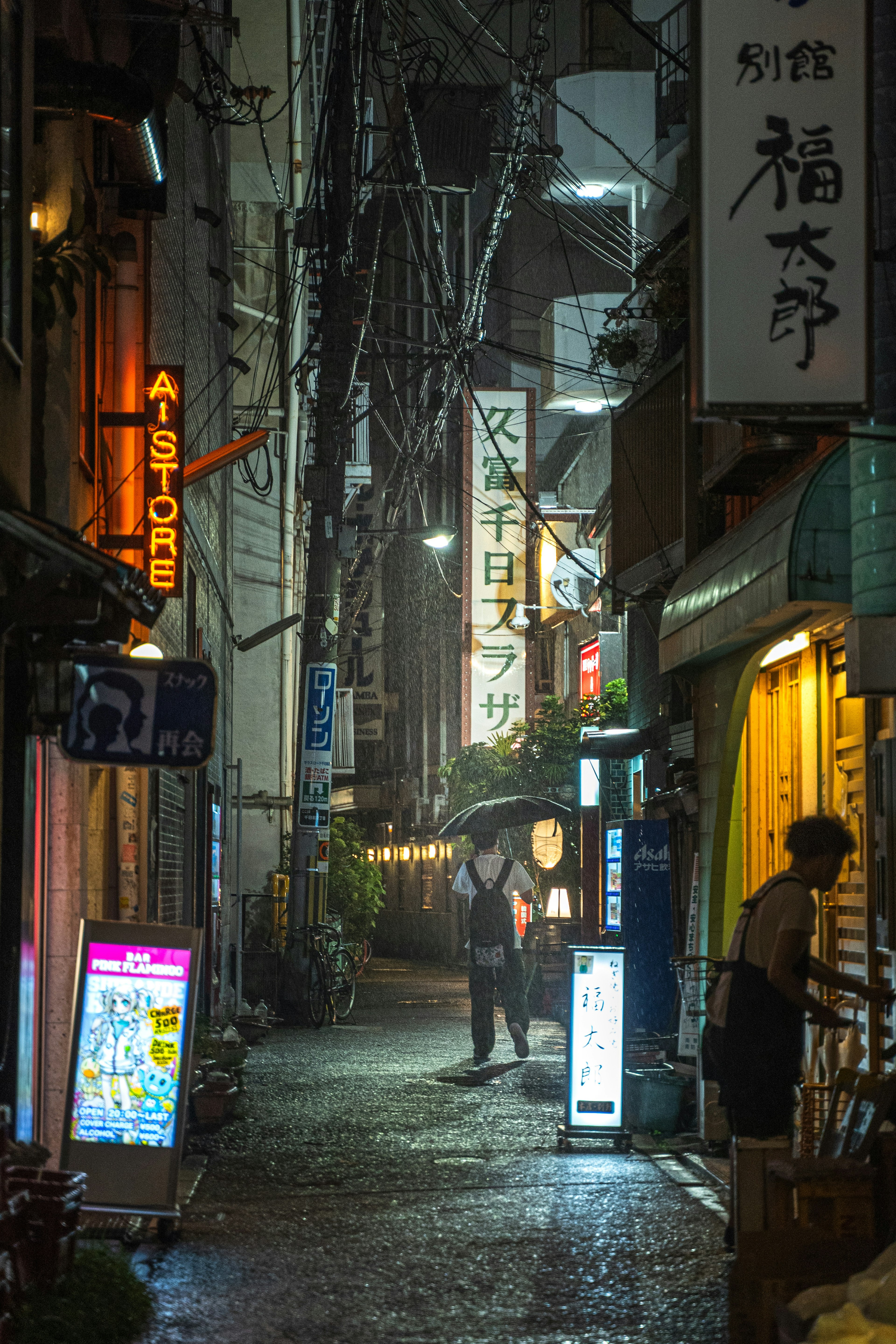 夜の静かな路地に立つ二人の人影と明かりが灯る看板