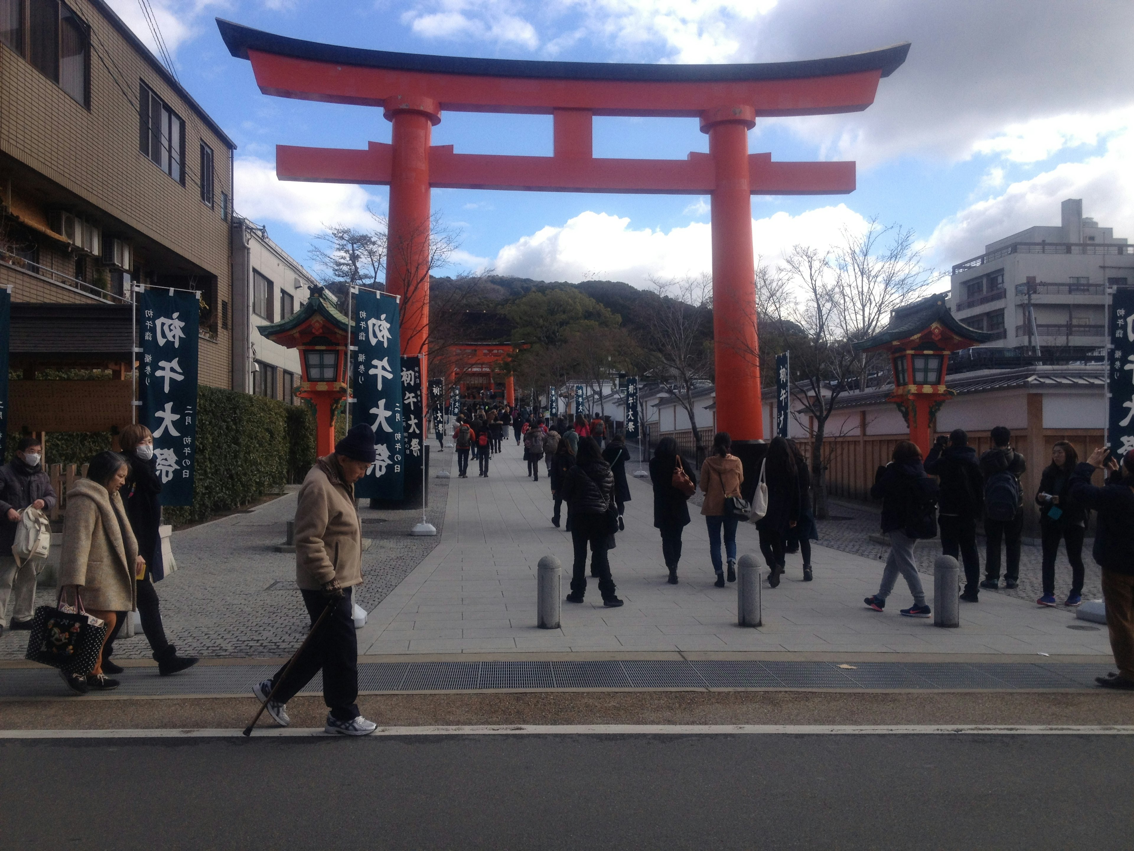 Red torii gate with people walking through