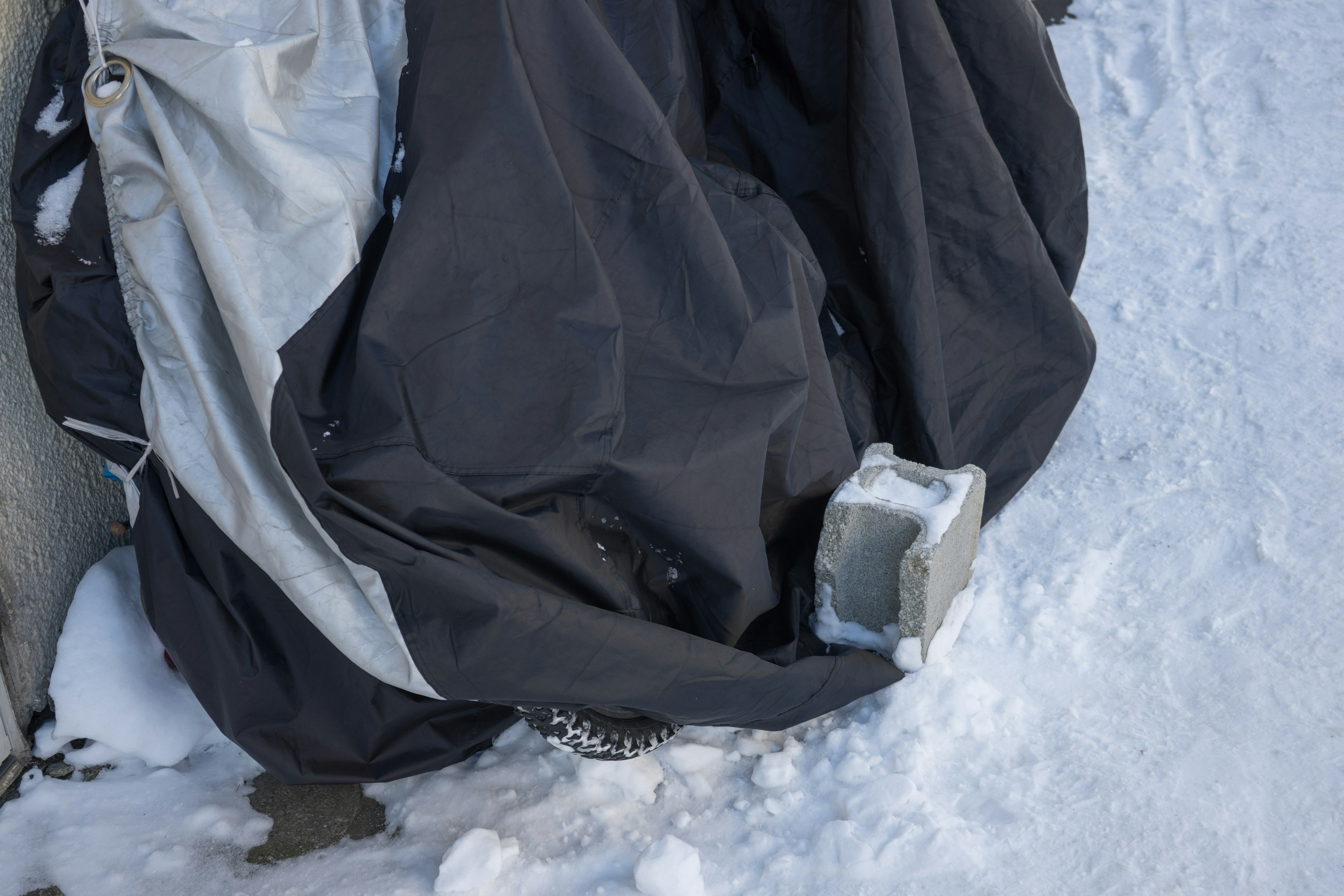 黒いカバーが雪の上に置かれている様子