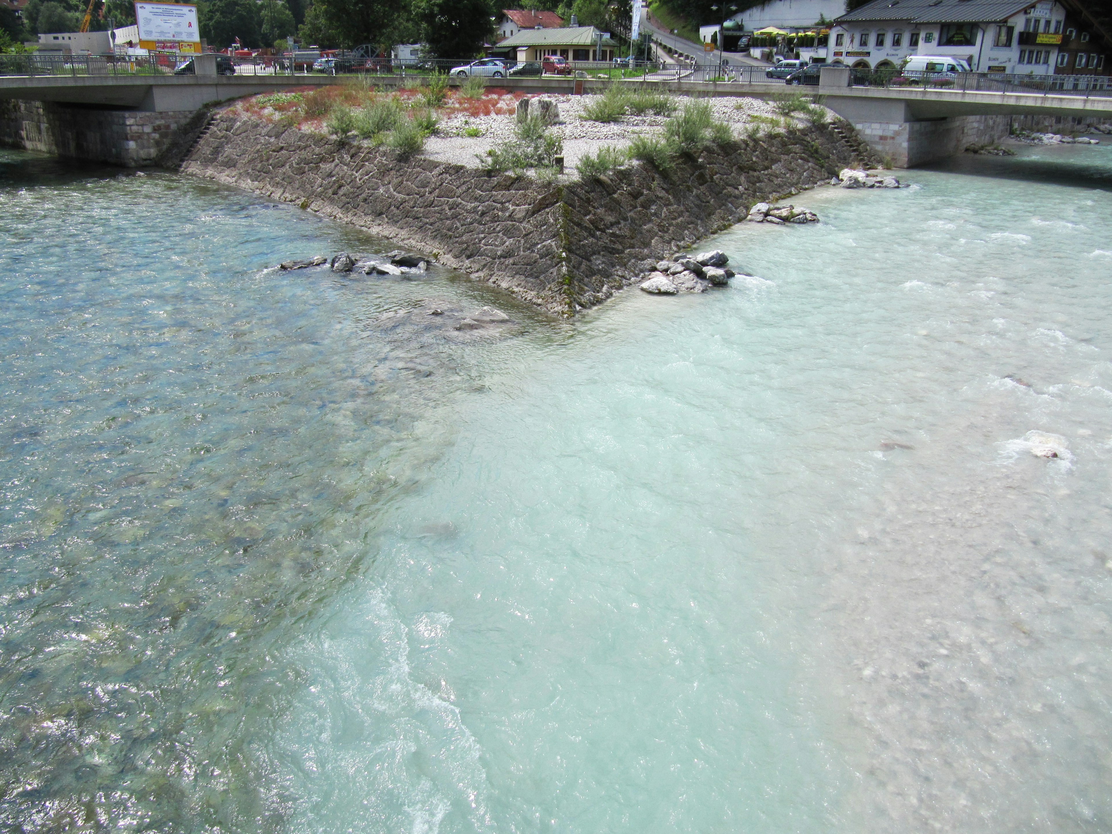 Bifurcación de río con aguas azules y blancas fluyendo