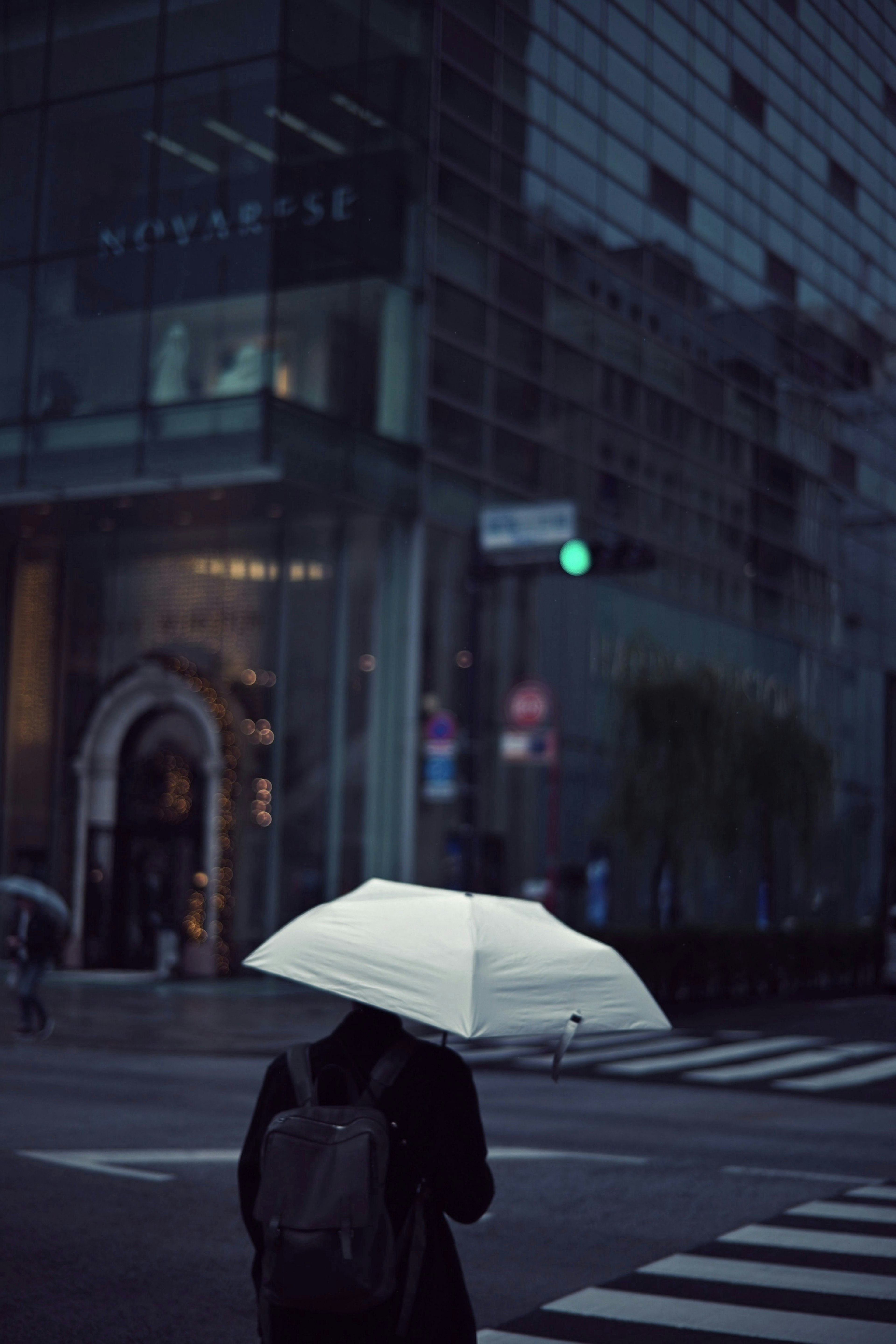 在城市环境中撑着白色雨伞的人