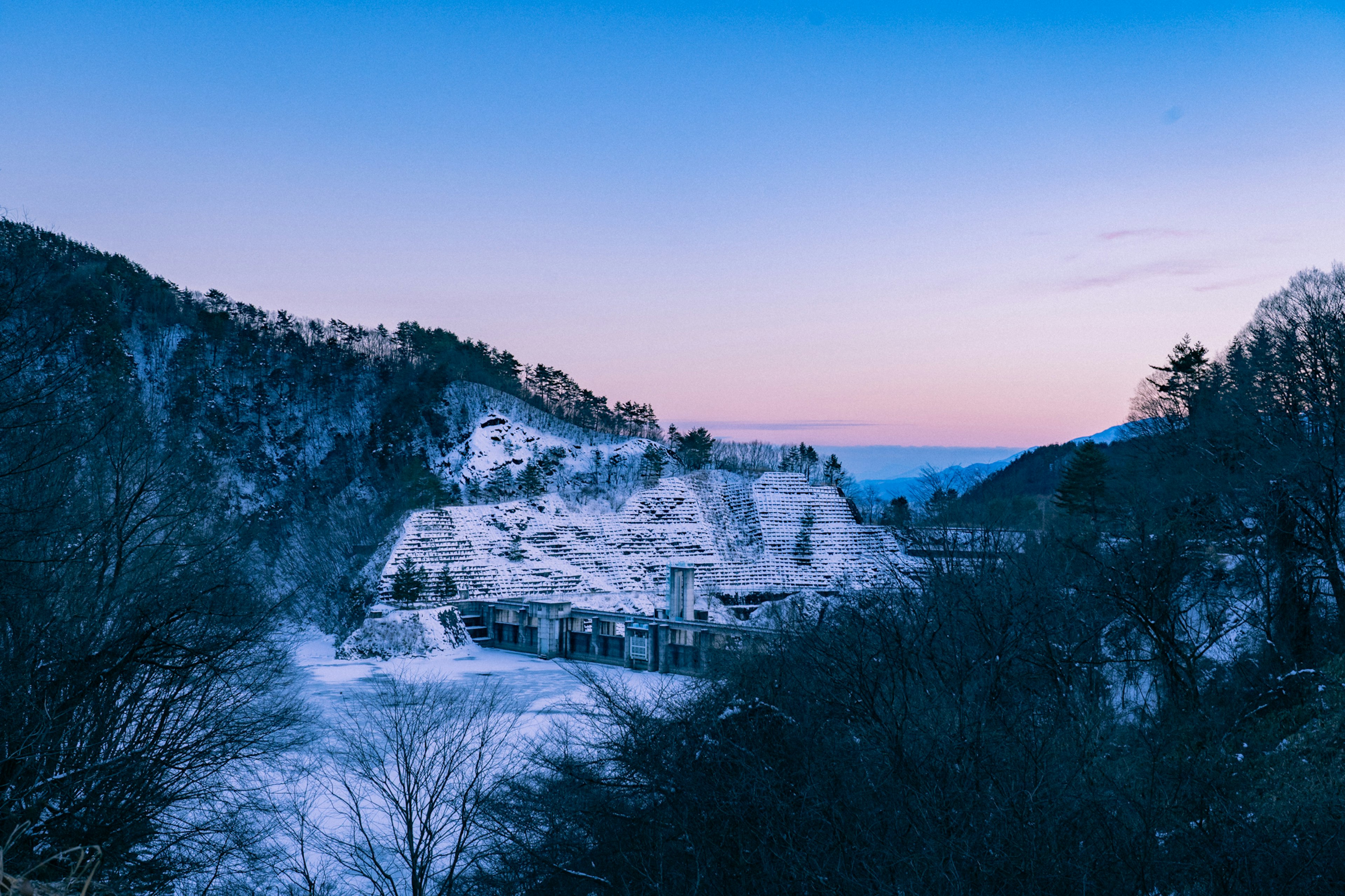 雪に覆われた山の風景と静かな夕暮れの空