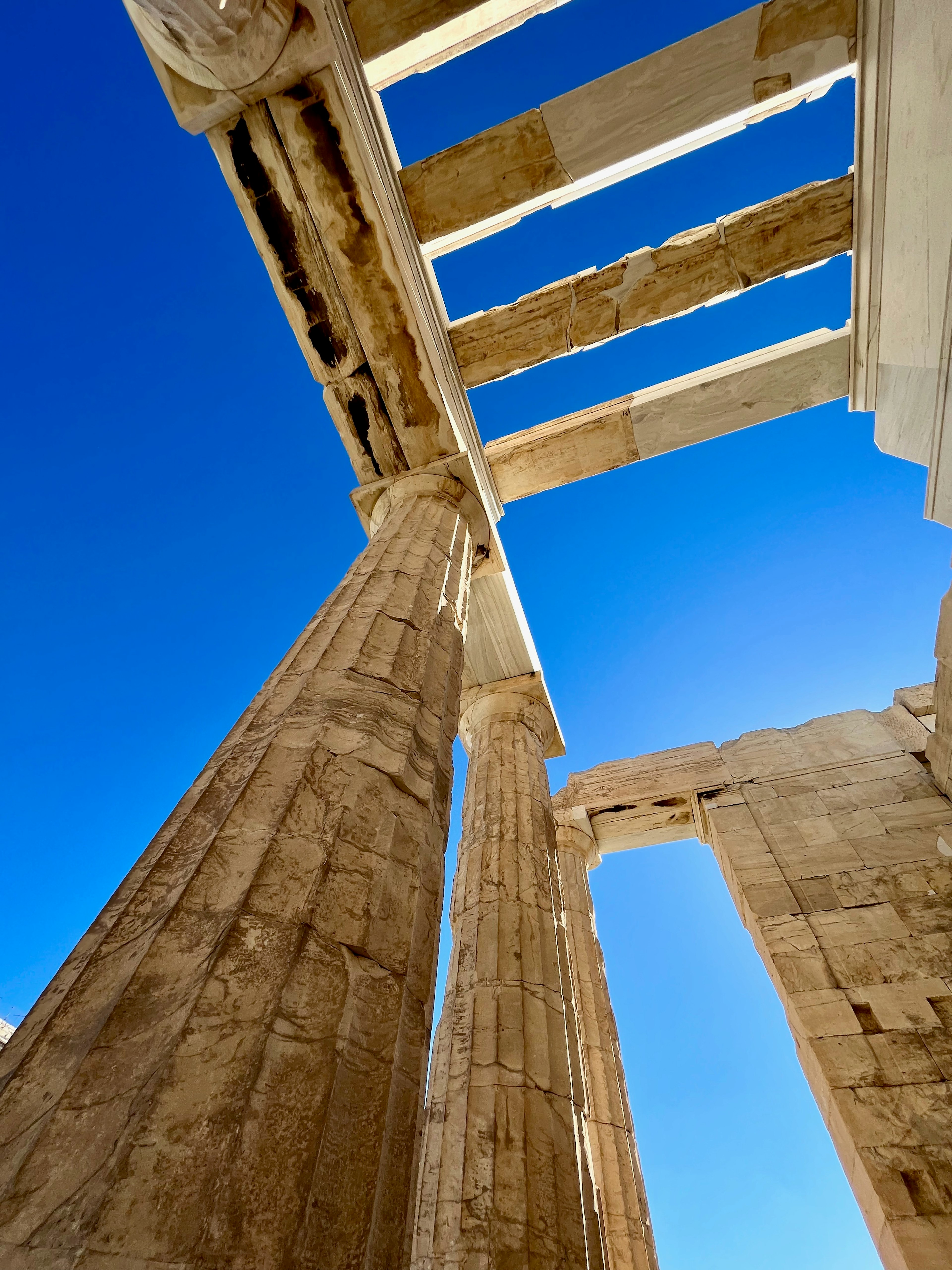 Piliers anciens et ruines architecturales sous un ciel bleu