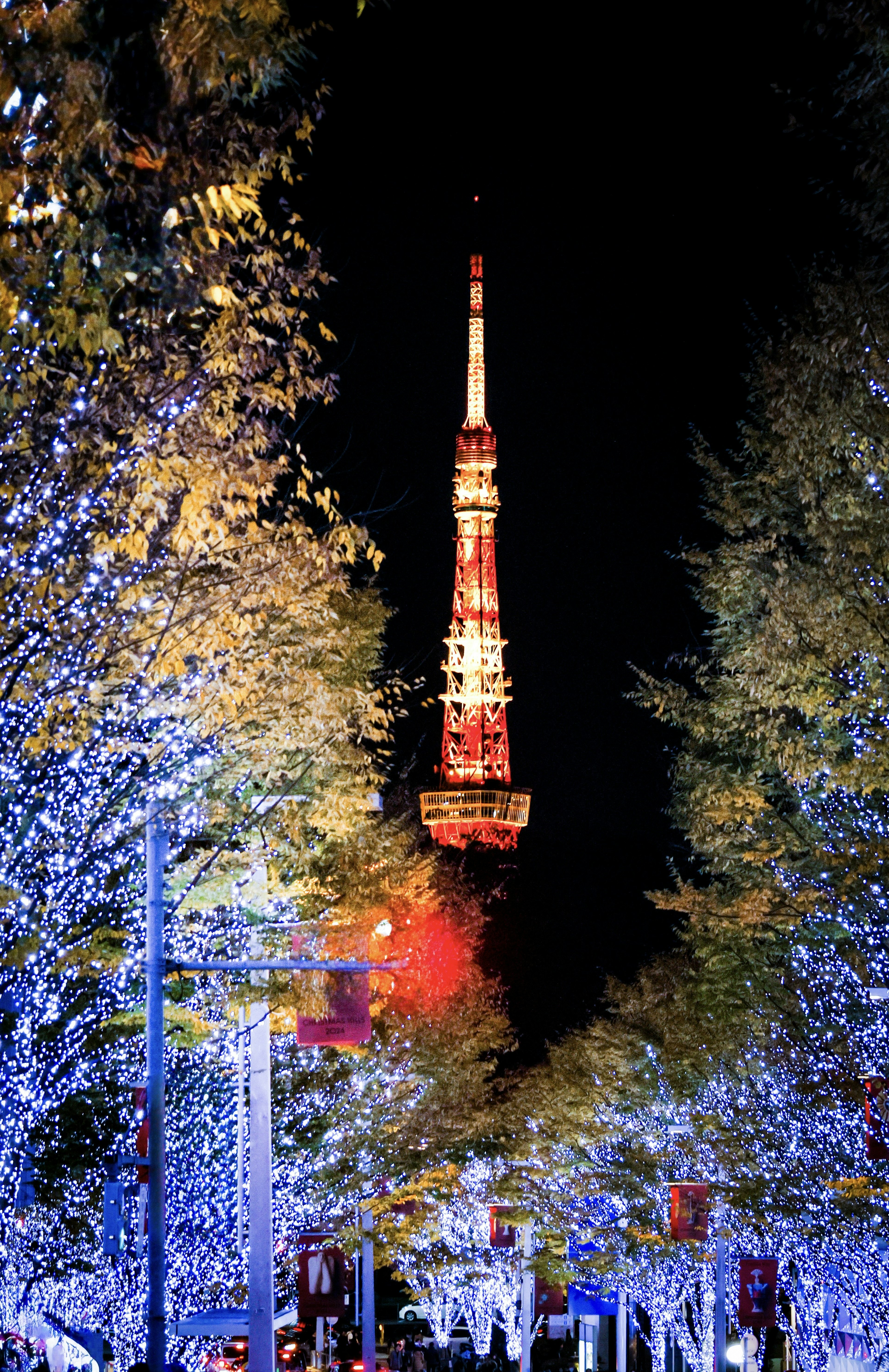 Tokyo Tower illuminated at night surrounded by vibrant lights