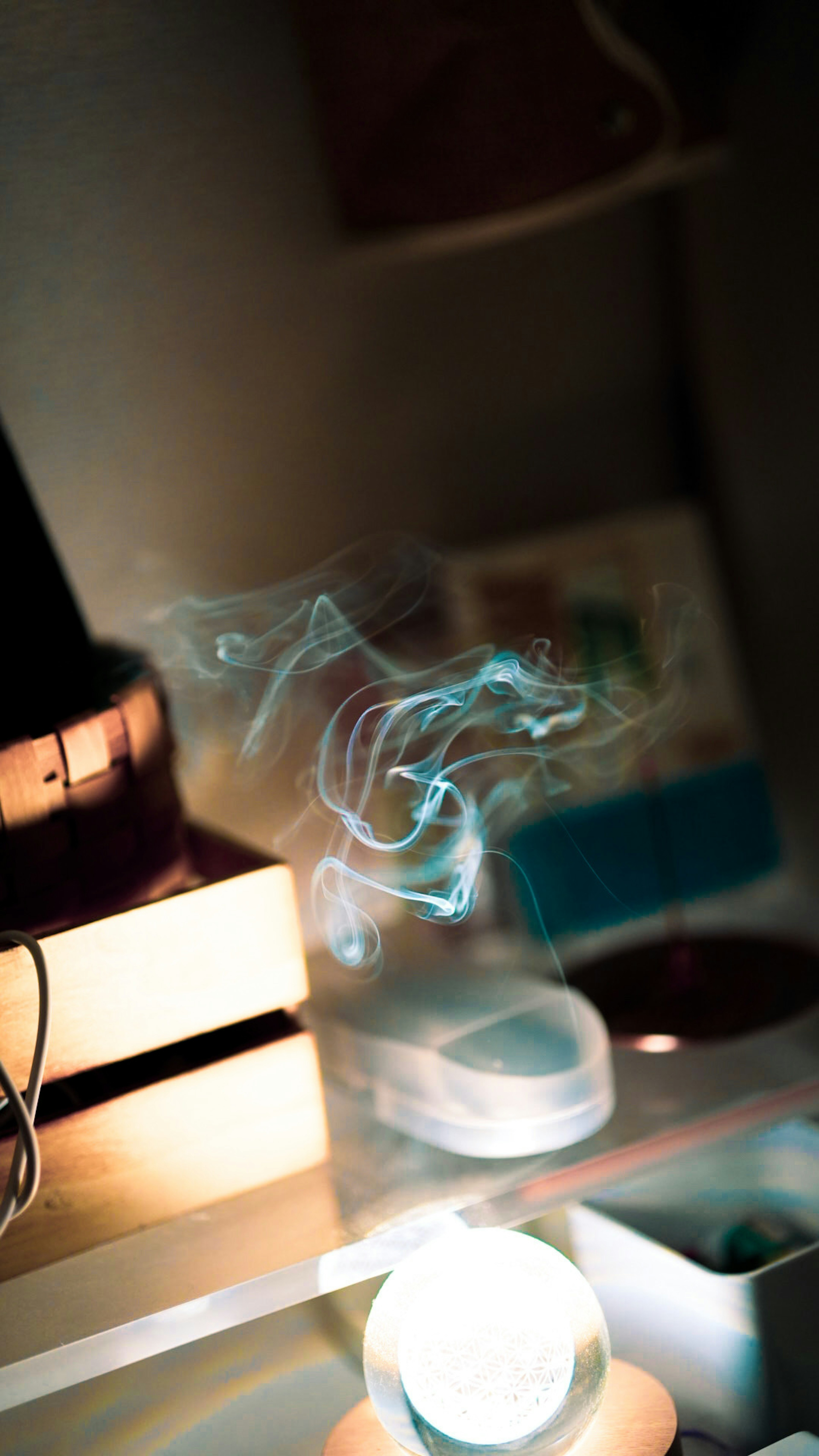 Faint blue smoke swirling above a desk with various objects