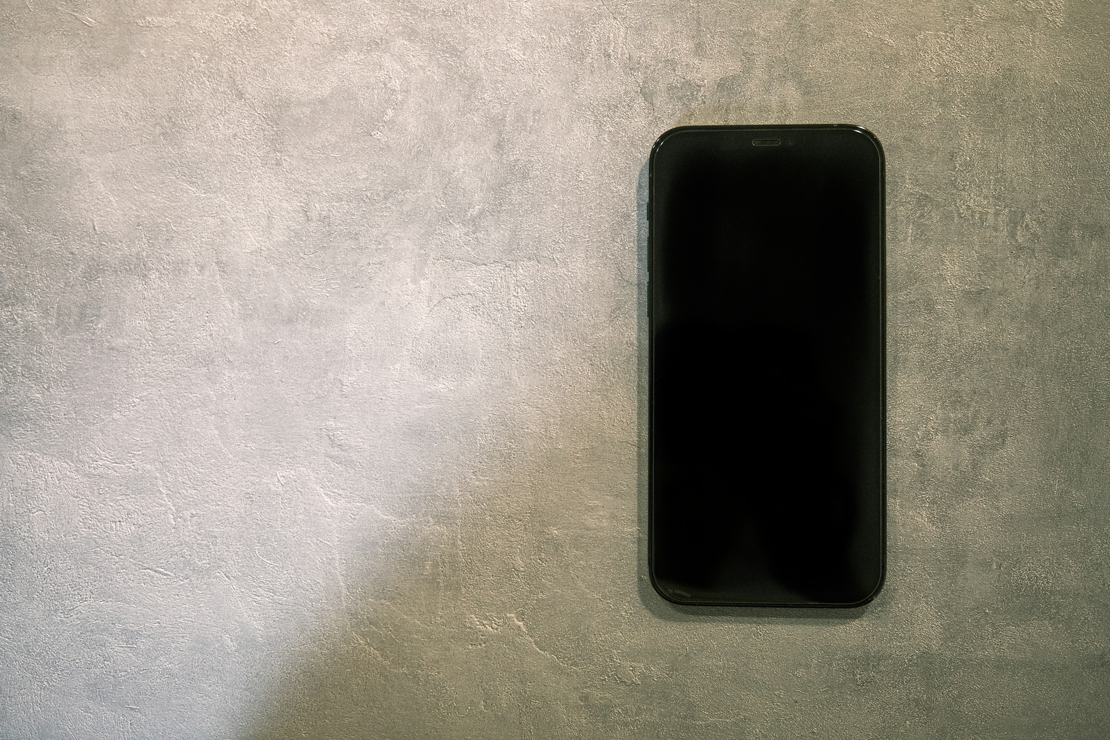 Smartphone negro en una pared gris