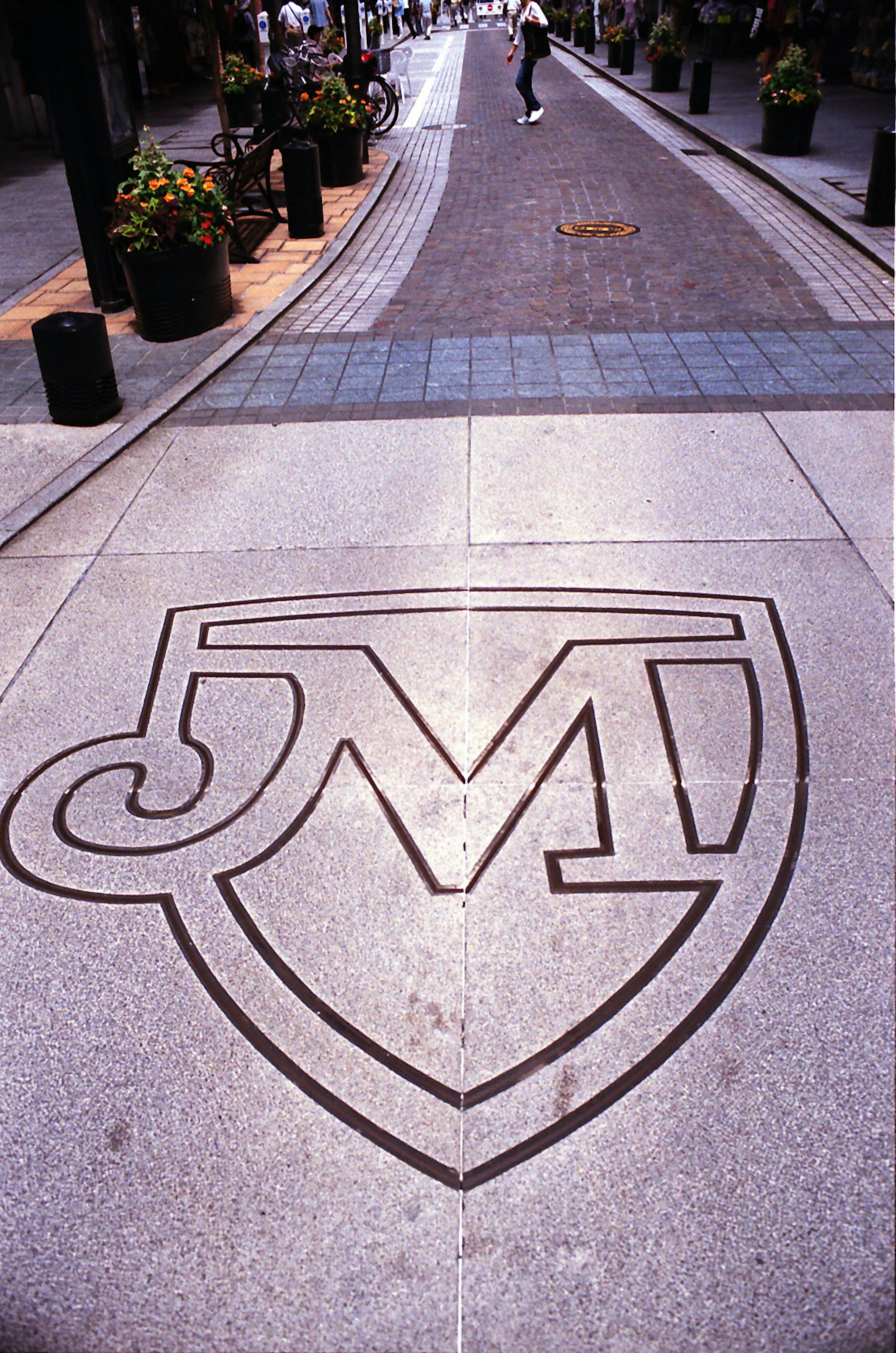 Diseño del logo JM incrustado en una calle pavimentada