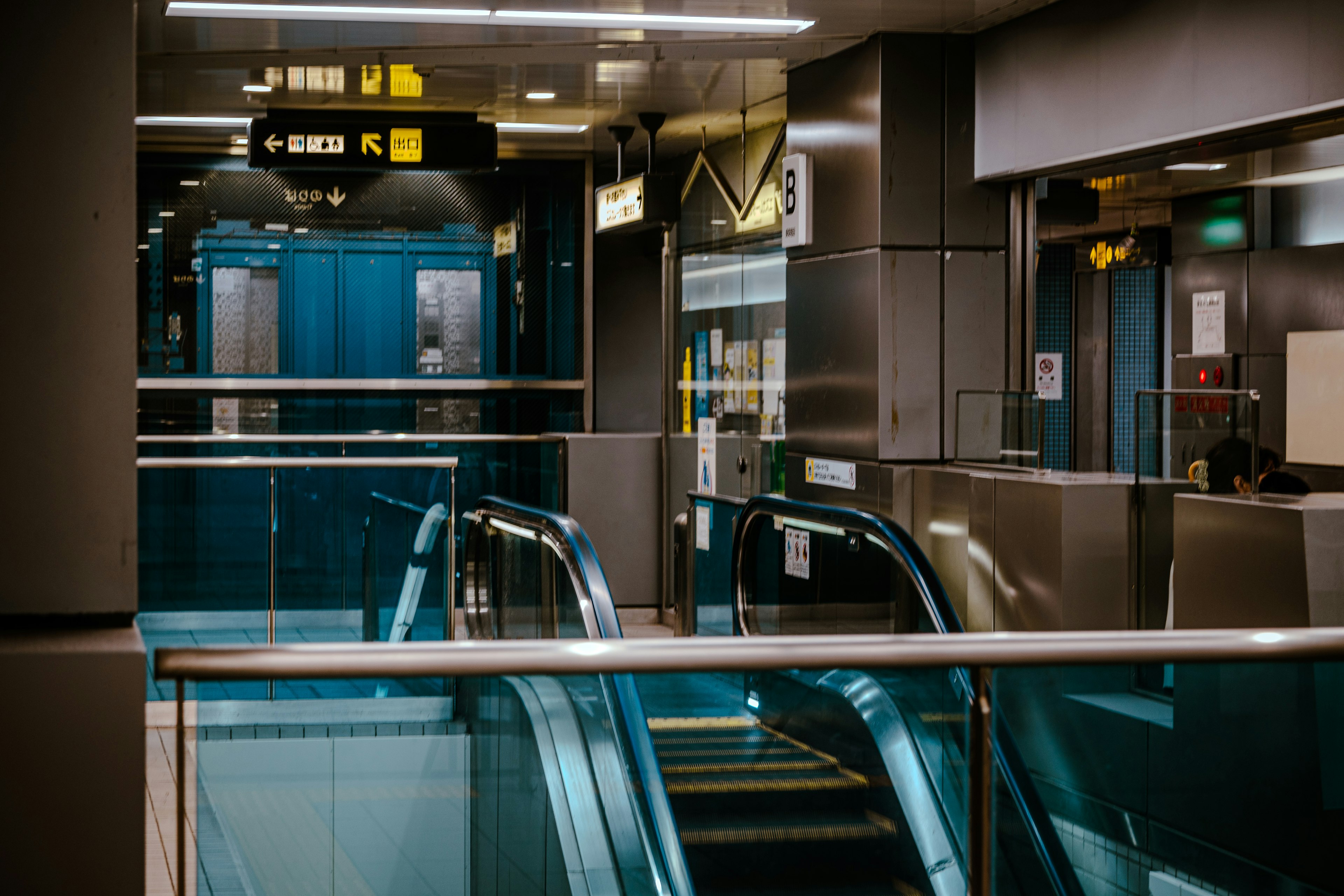 エスカレーターと金属的な内装の近代的な駅の内部