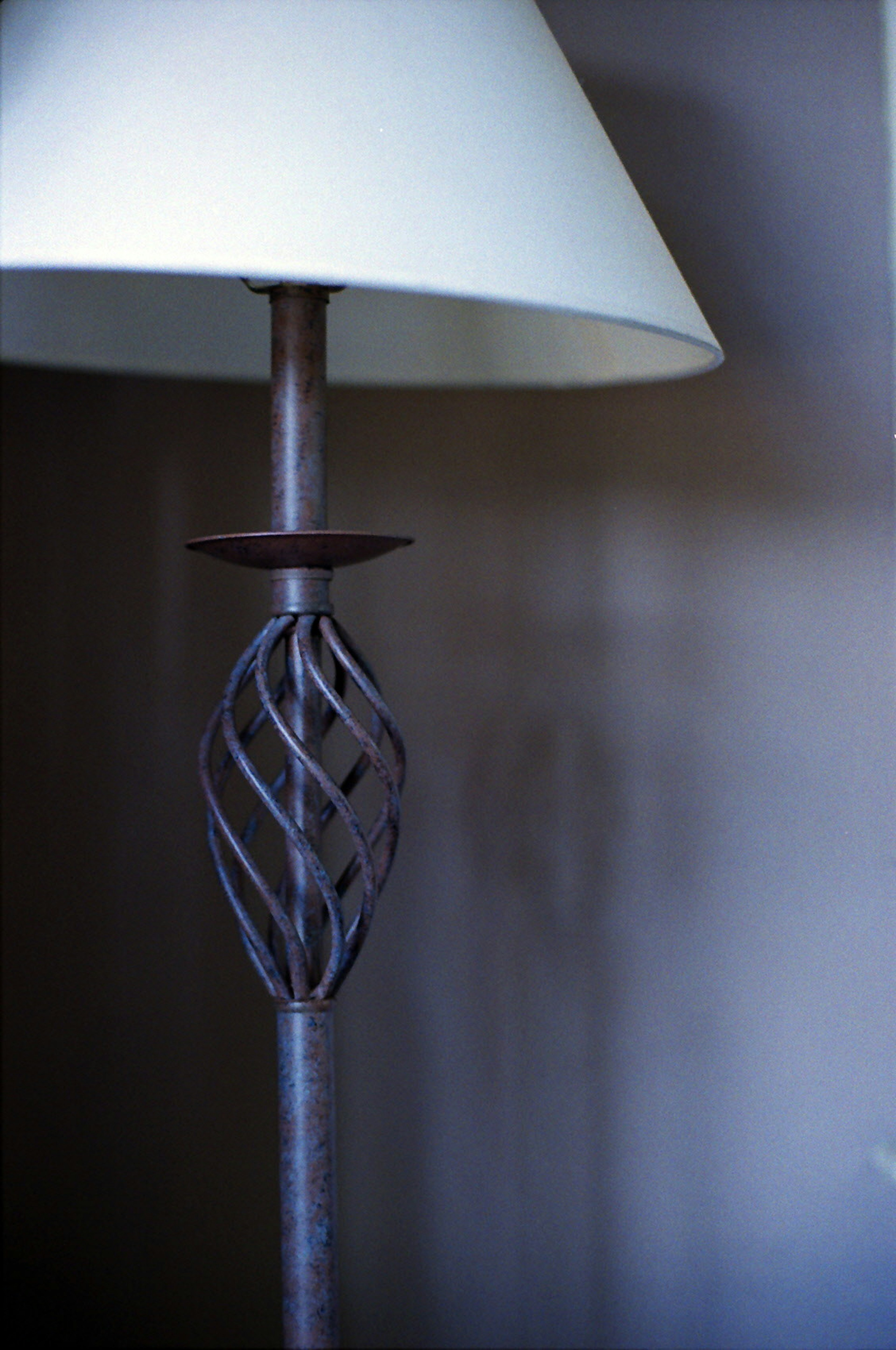 Lamp featuring a unique lampshade design and a metal stand with intricate detailing