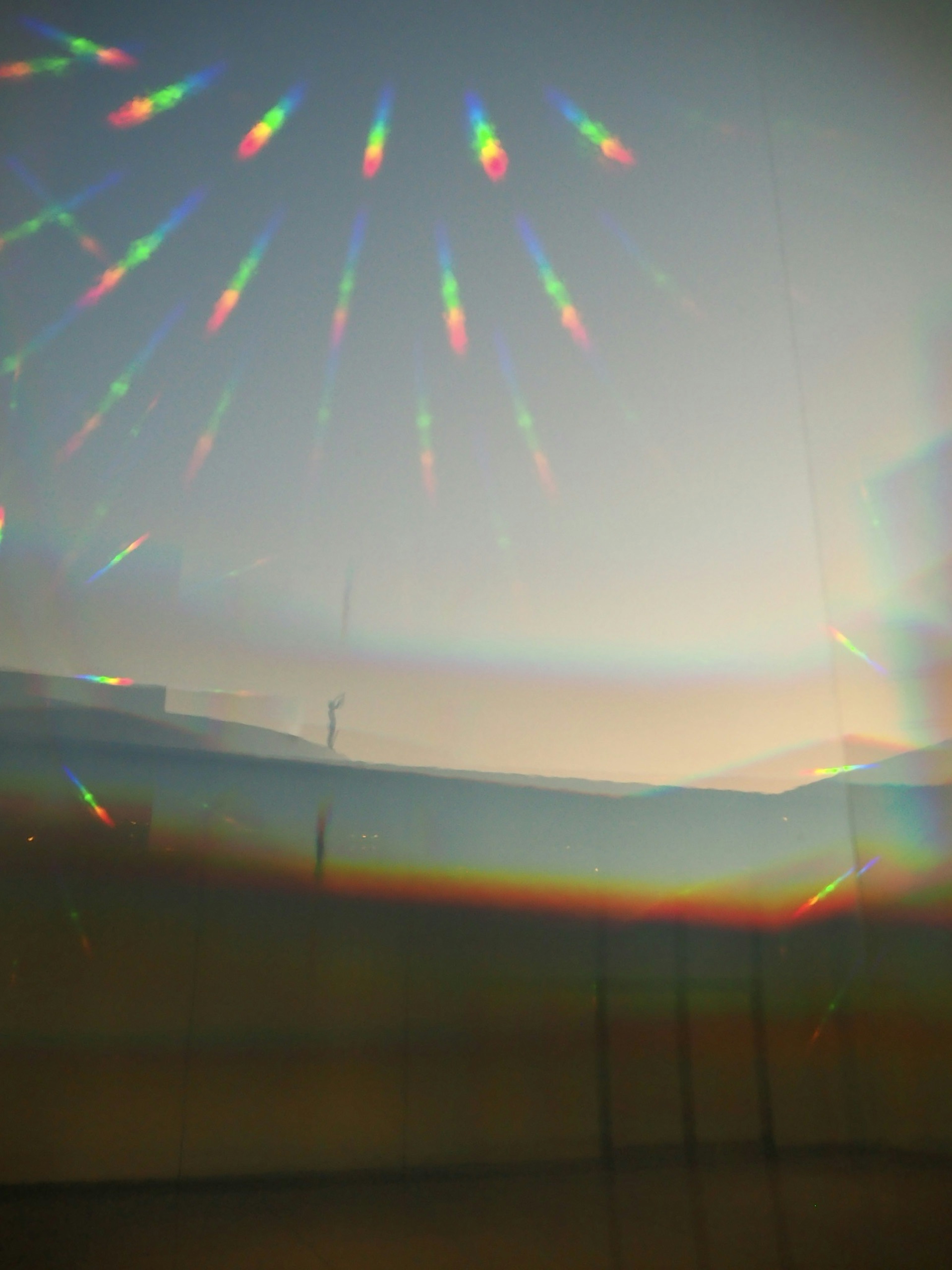 A photo featuring a spectrum of rainbow-colored light reflections