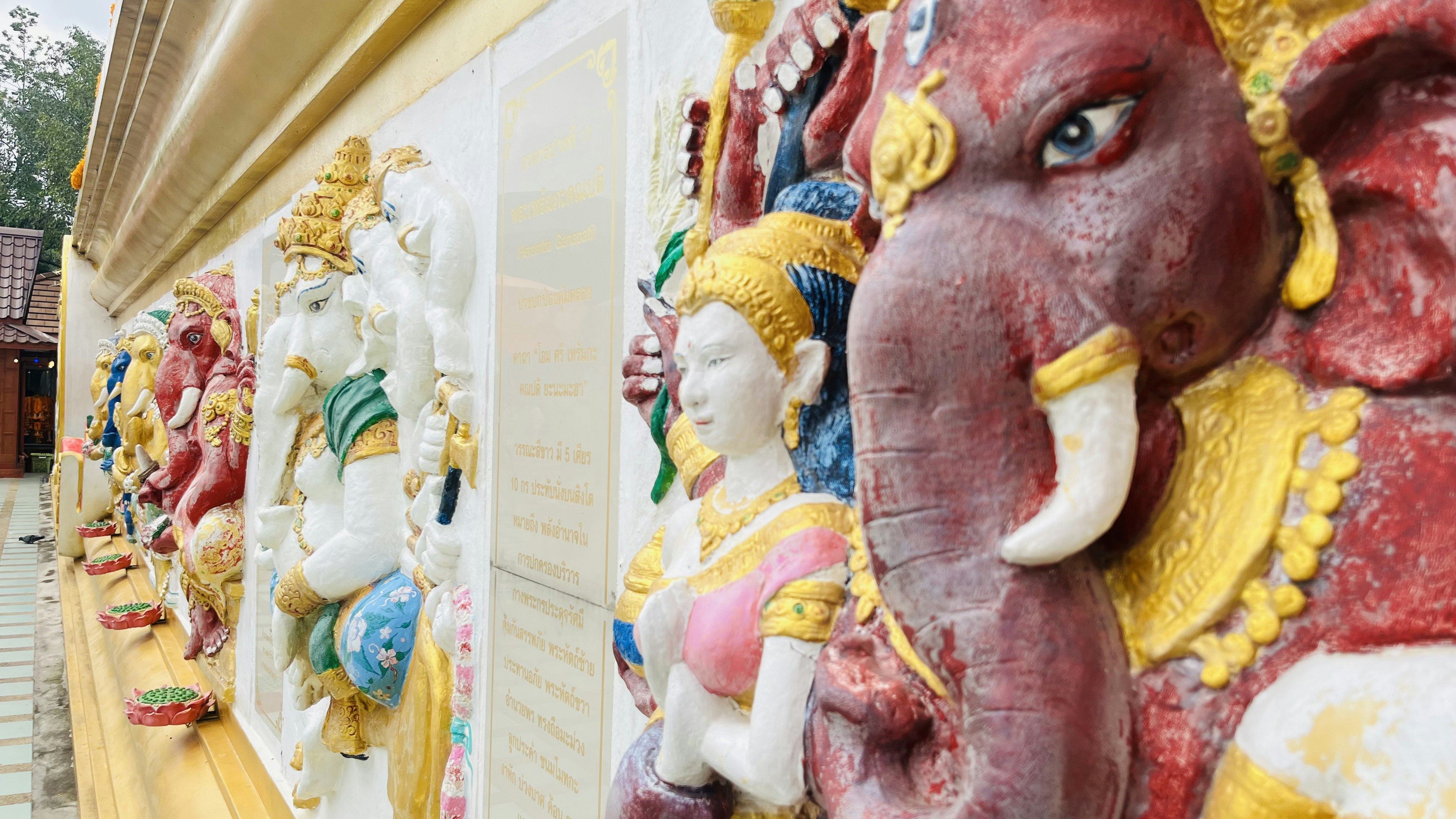 Esculturas coloridas de deidades con una figura prominente de Ganesh