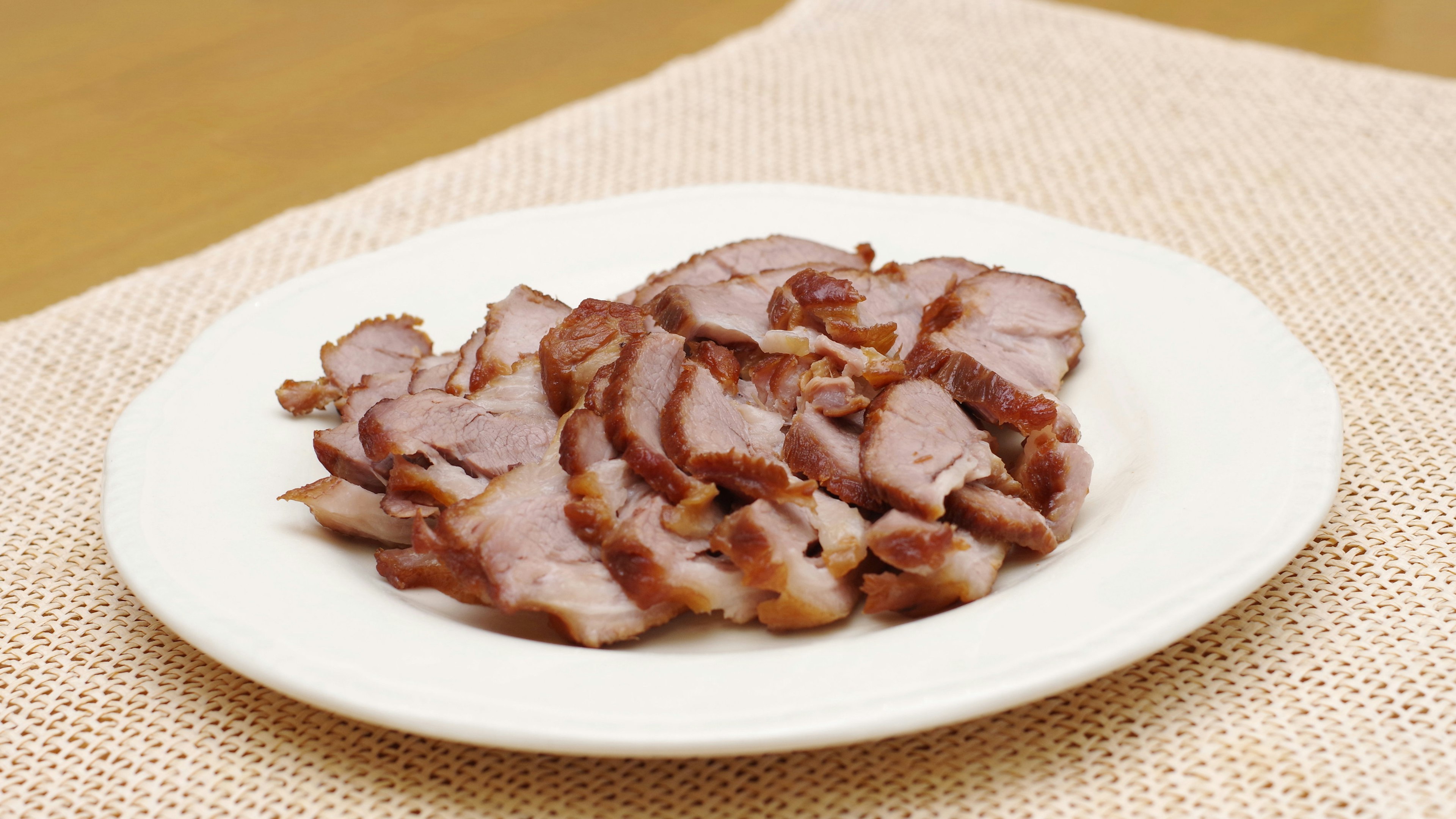 Sliced char siu on a white plate