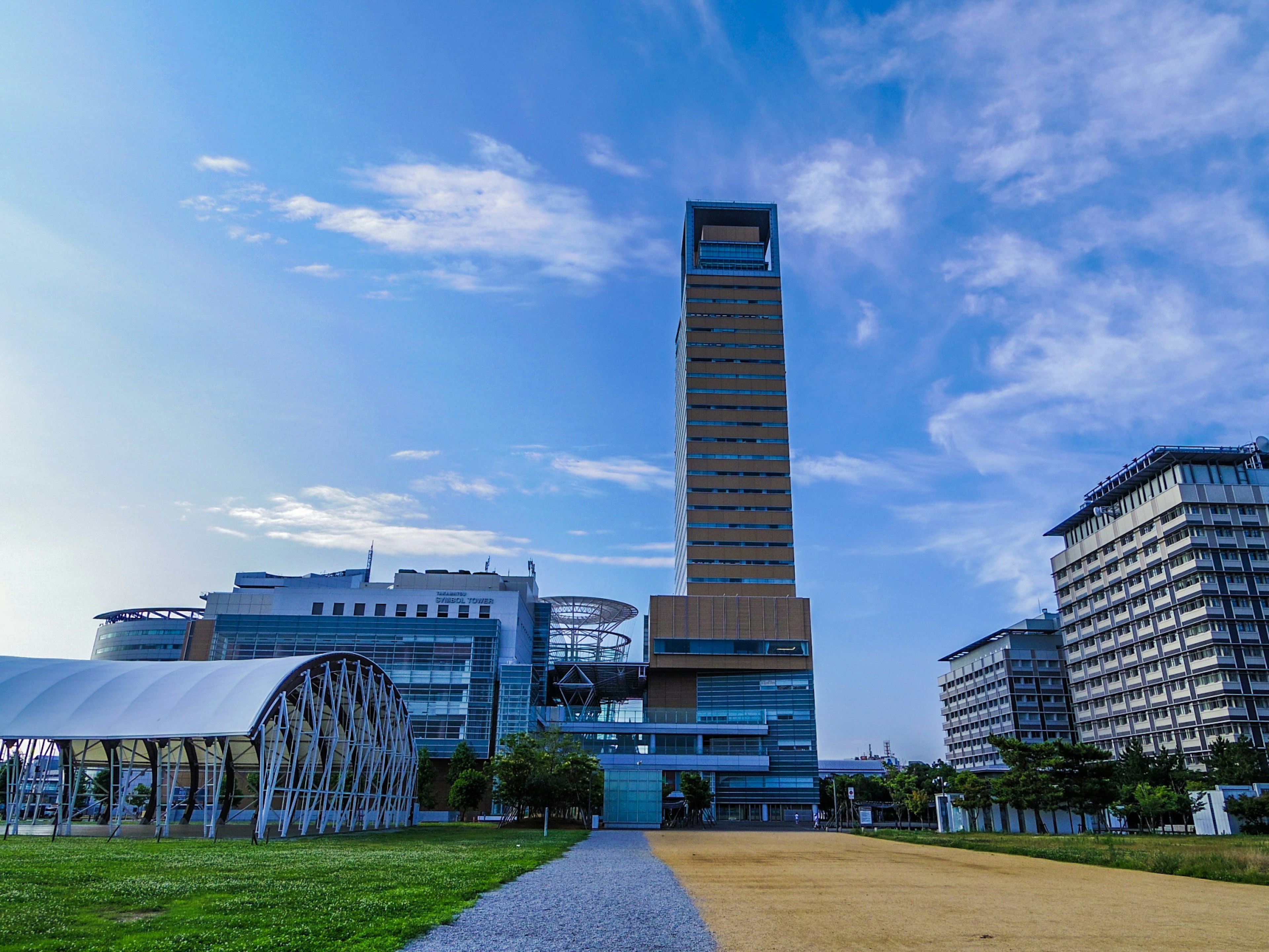 Skyline with a tall building and park under a blue sky