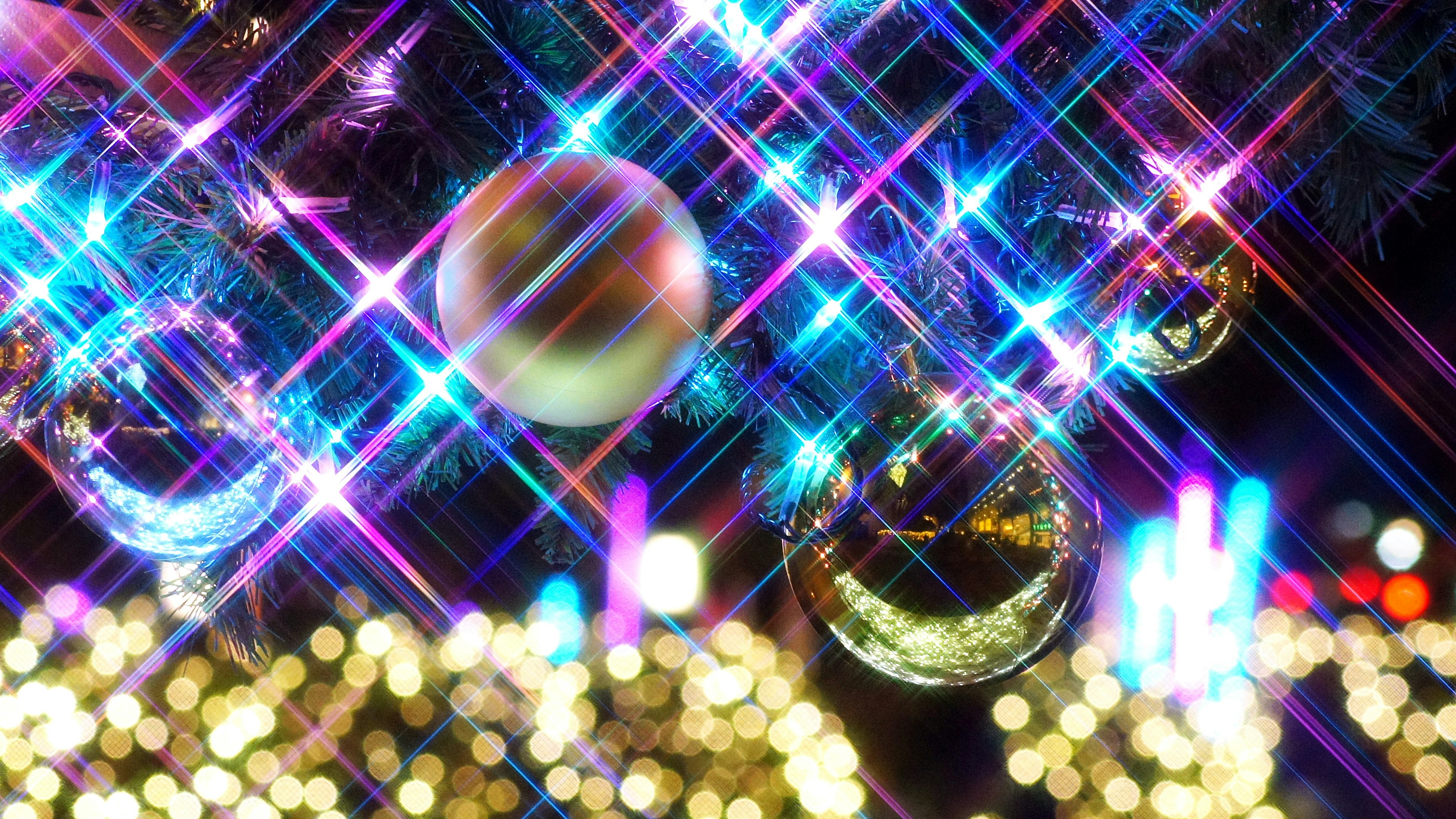 Shimmering Christmas ornaments with colorful lights in the background