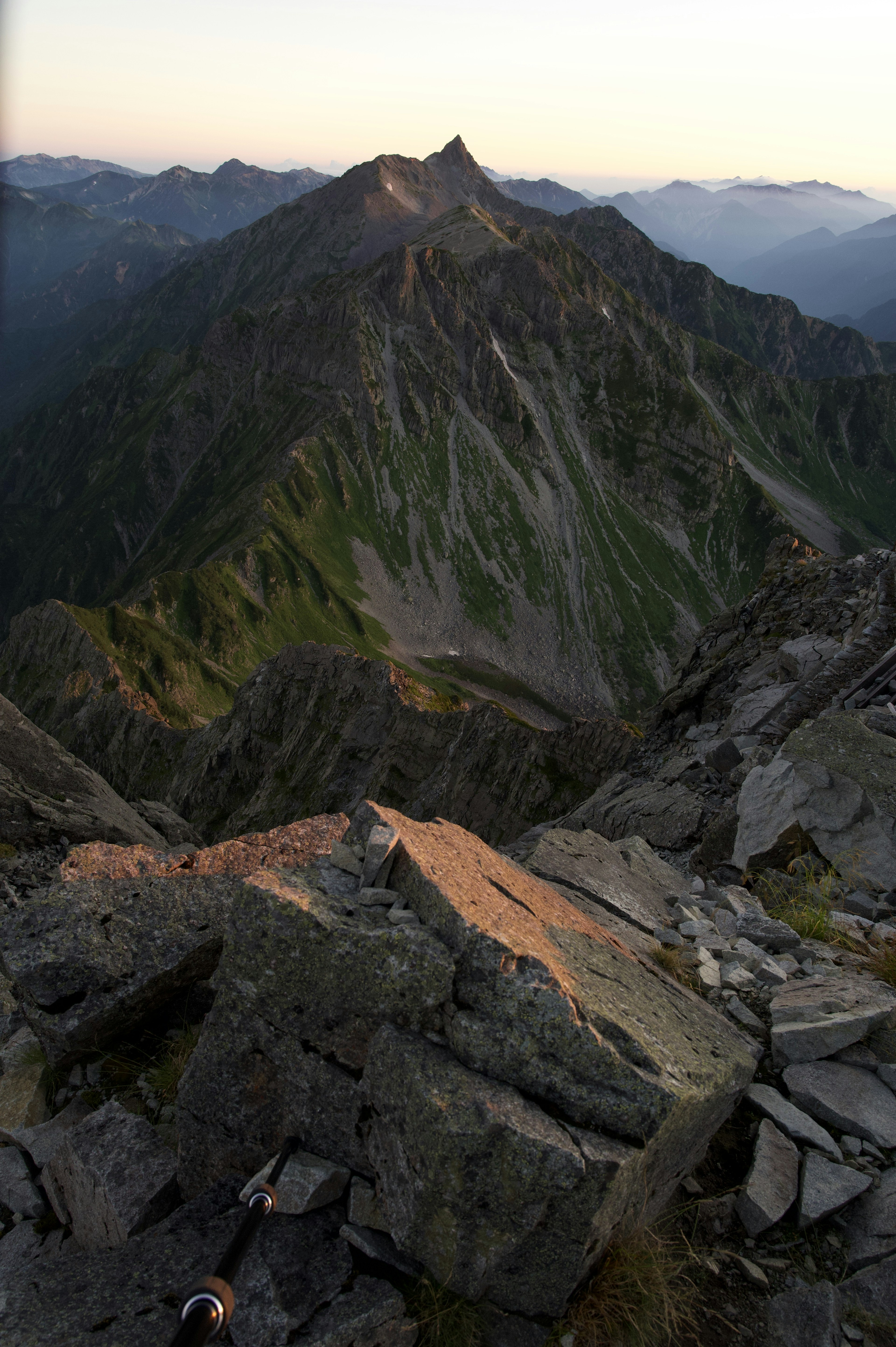 Atemberaubender Blick von einem Berggipfel mit grünen Bergen und felsigem Gelände