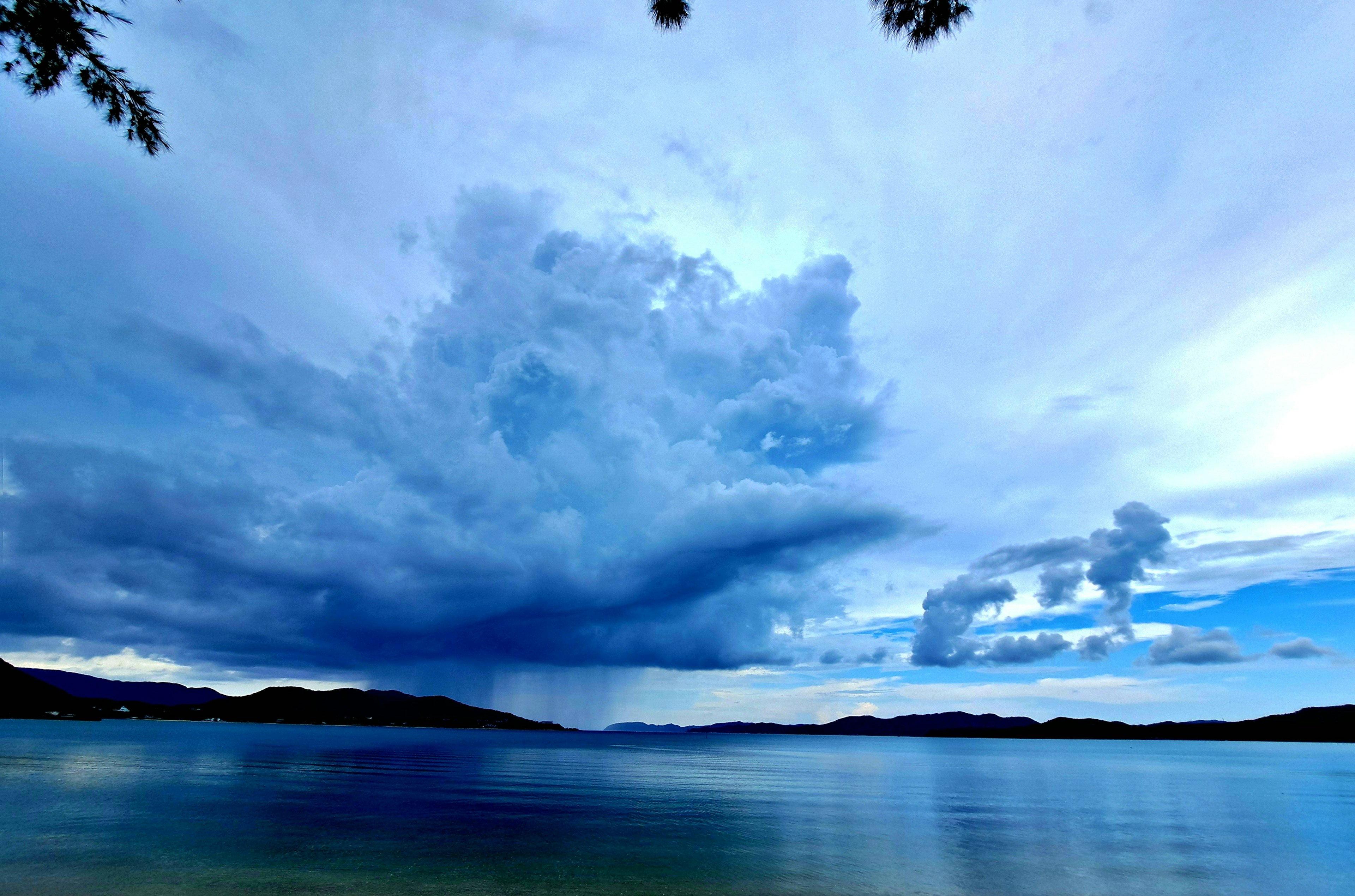 Eine malerische Aussicht auf einen See unter einem dramatischen blauen Himmel mit Wolken