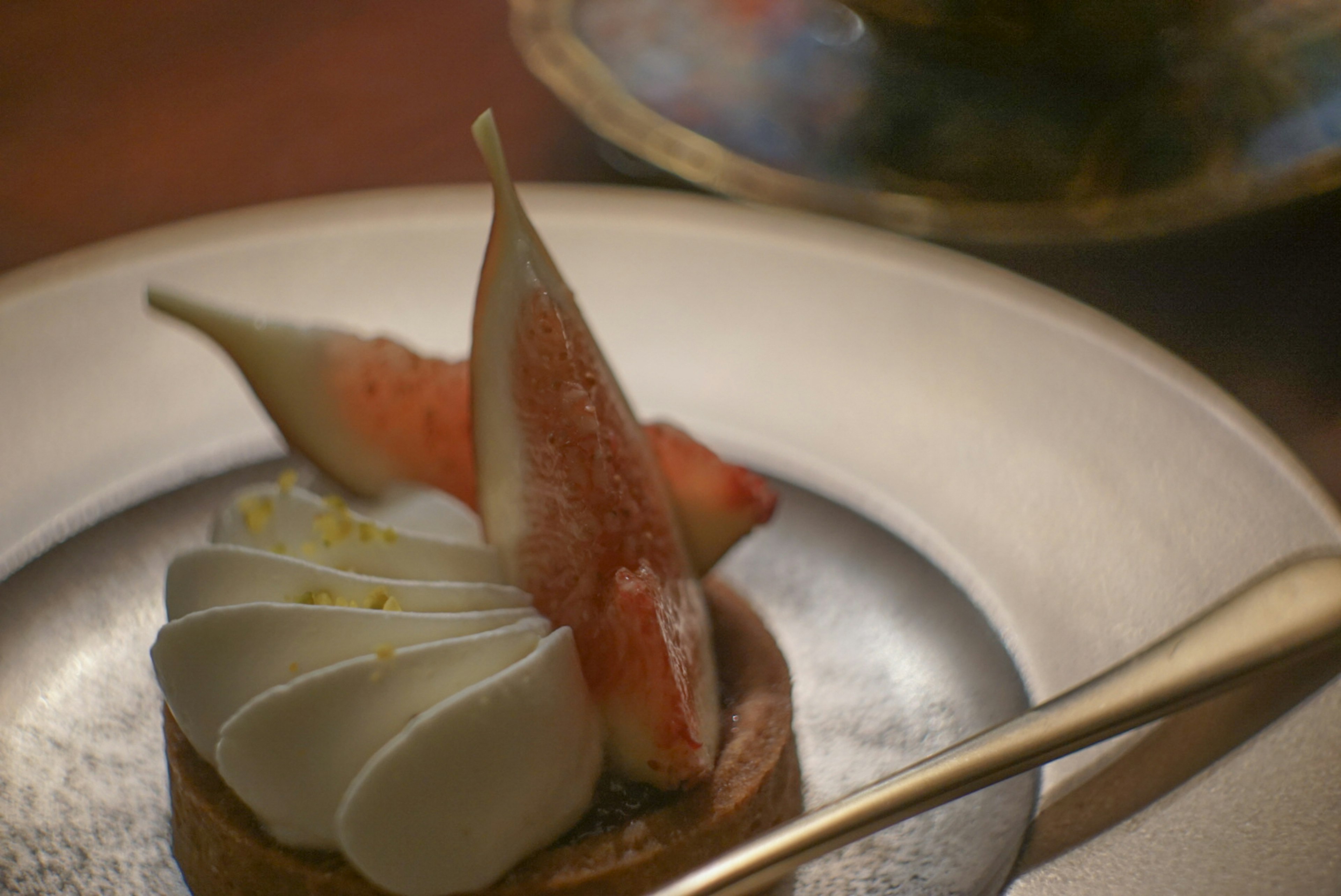 Un dessert joliment présenté avec une tarte garnie de crème et de décorations de fruits