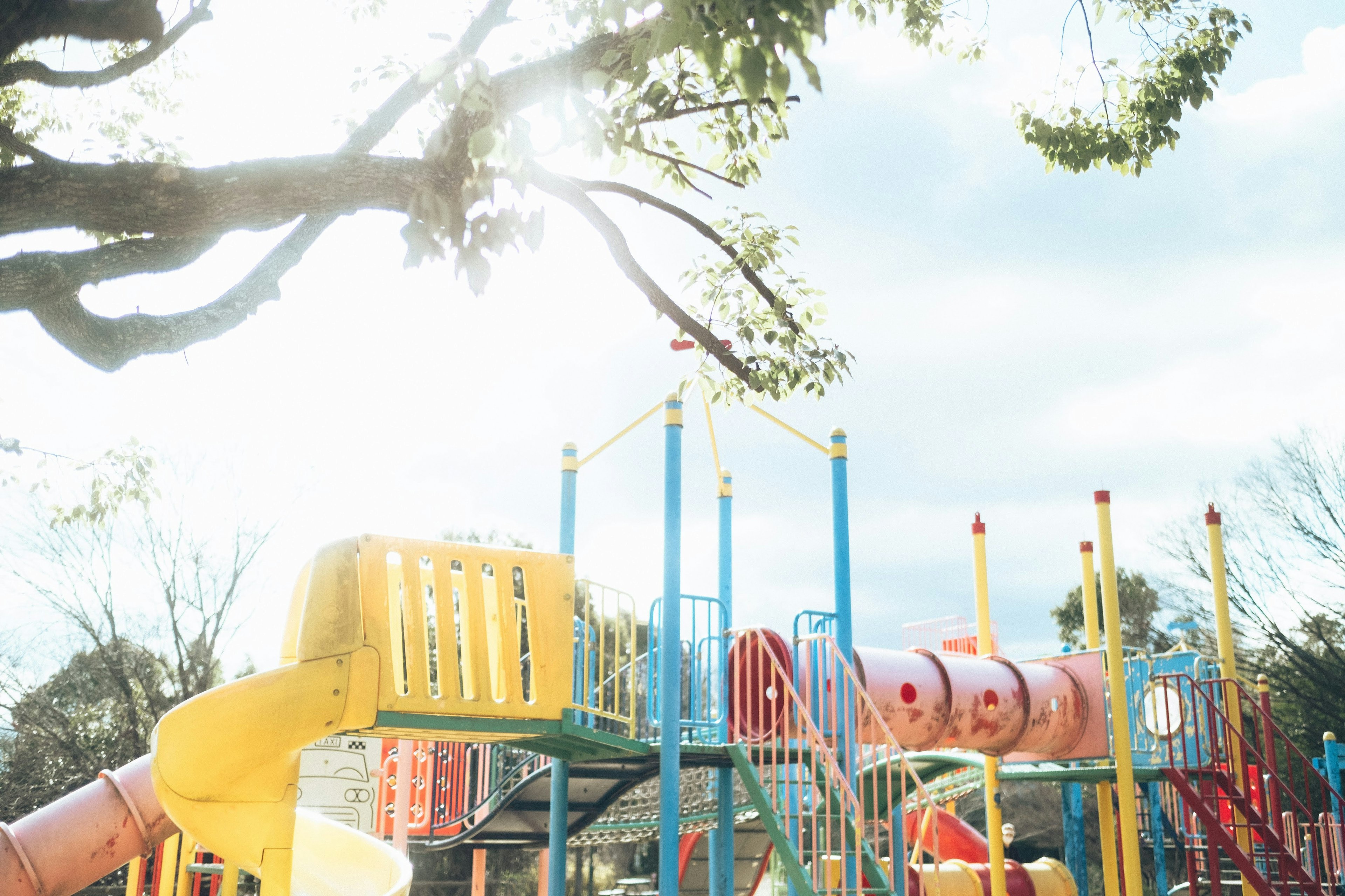 Bunter Spielplatz mit Rutschen und Klettergerüsten unter einem hellen Himmel