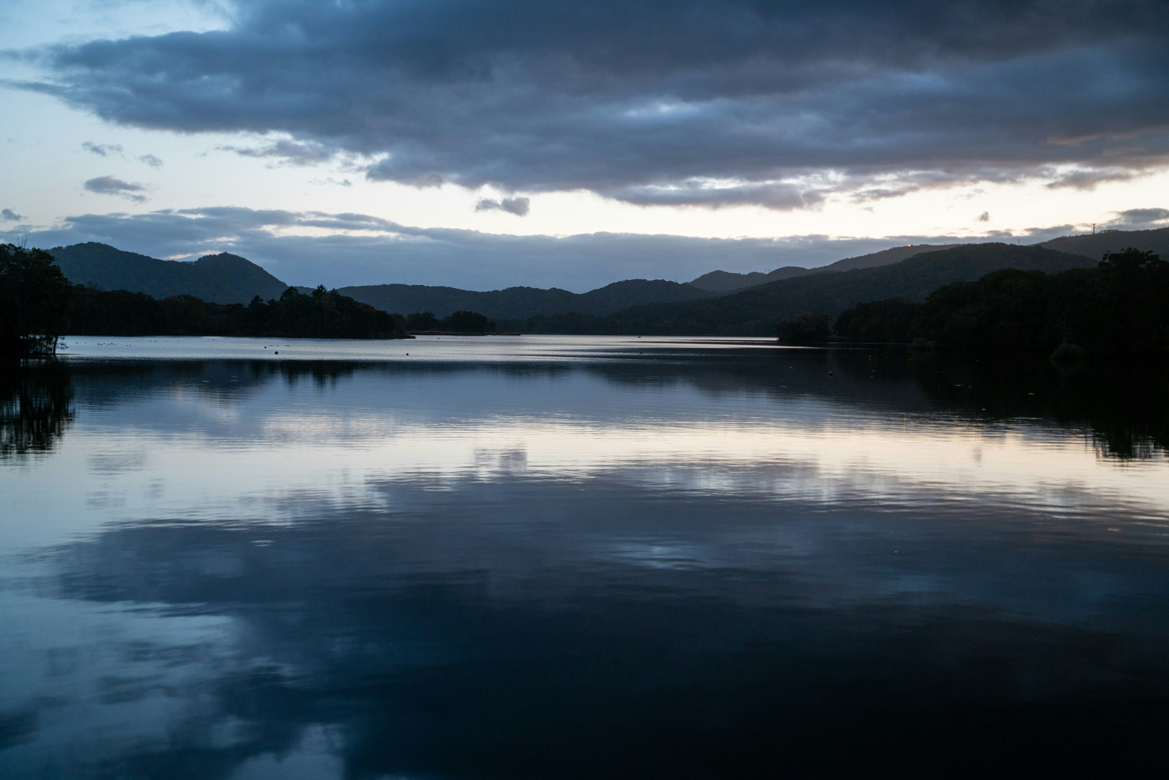 Ruhige Landschaft von See und Bergen Wolken spiegeln sich in der Dämmerung