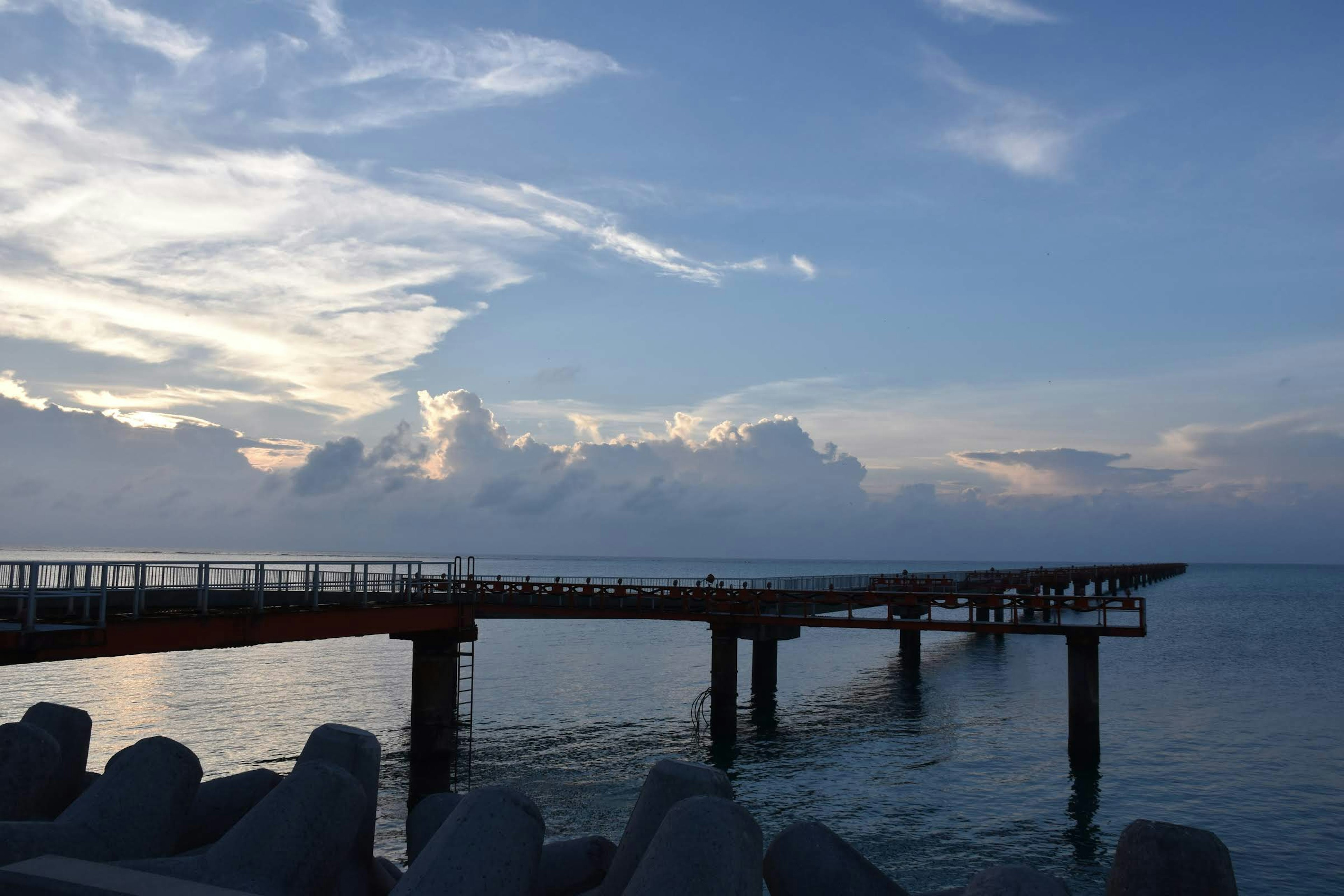 Muelle que se extiende en el mar tranquilo bajo un cielo azul