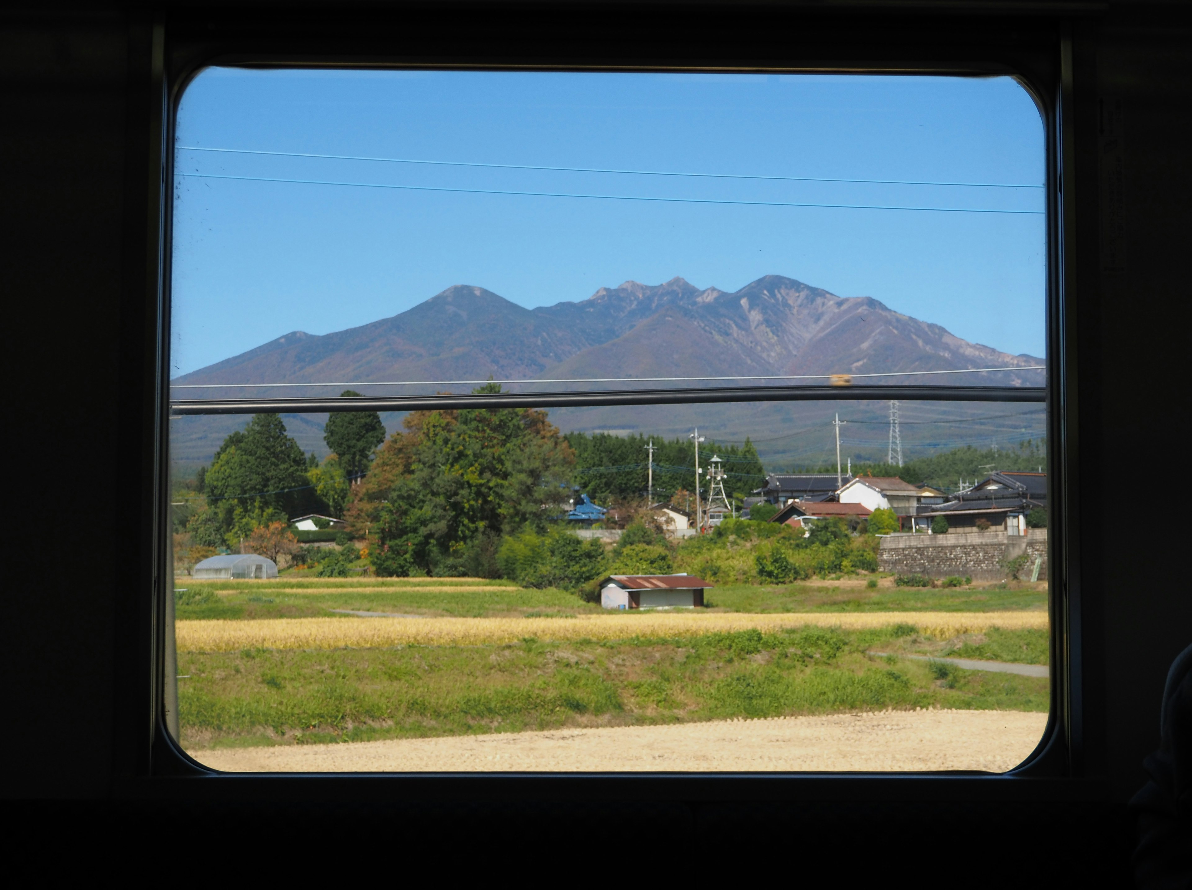 電車の窓から見える美しい山と緑の風景