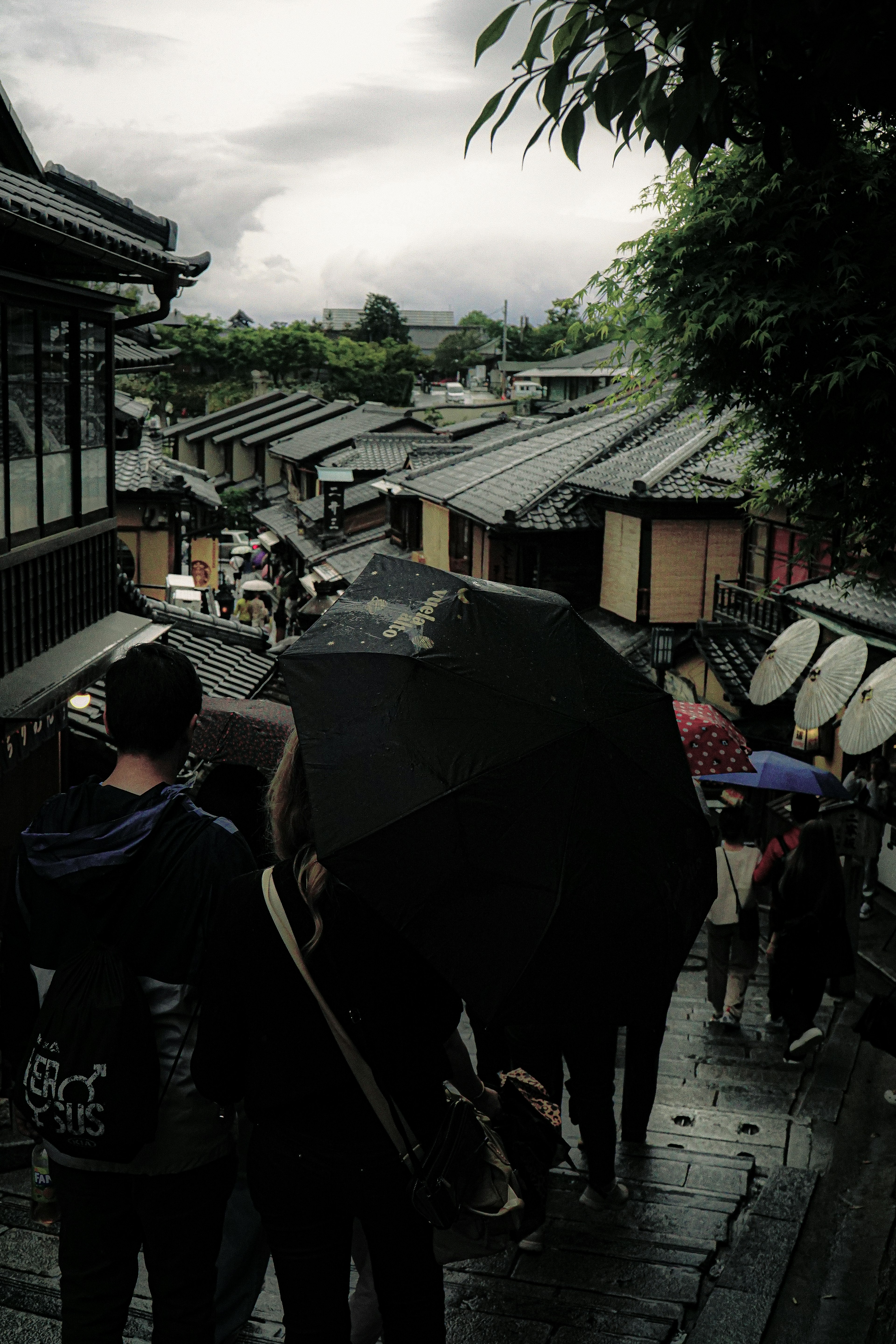 Orang-orang berjalan dengan payung di jalanan bersejarah Kyoto