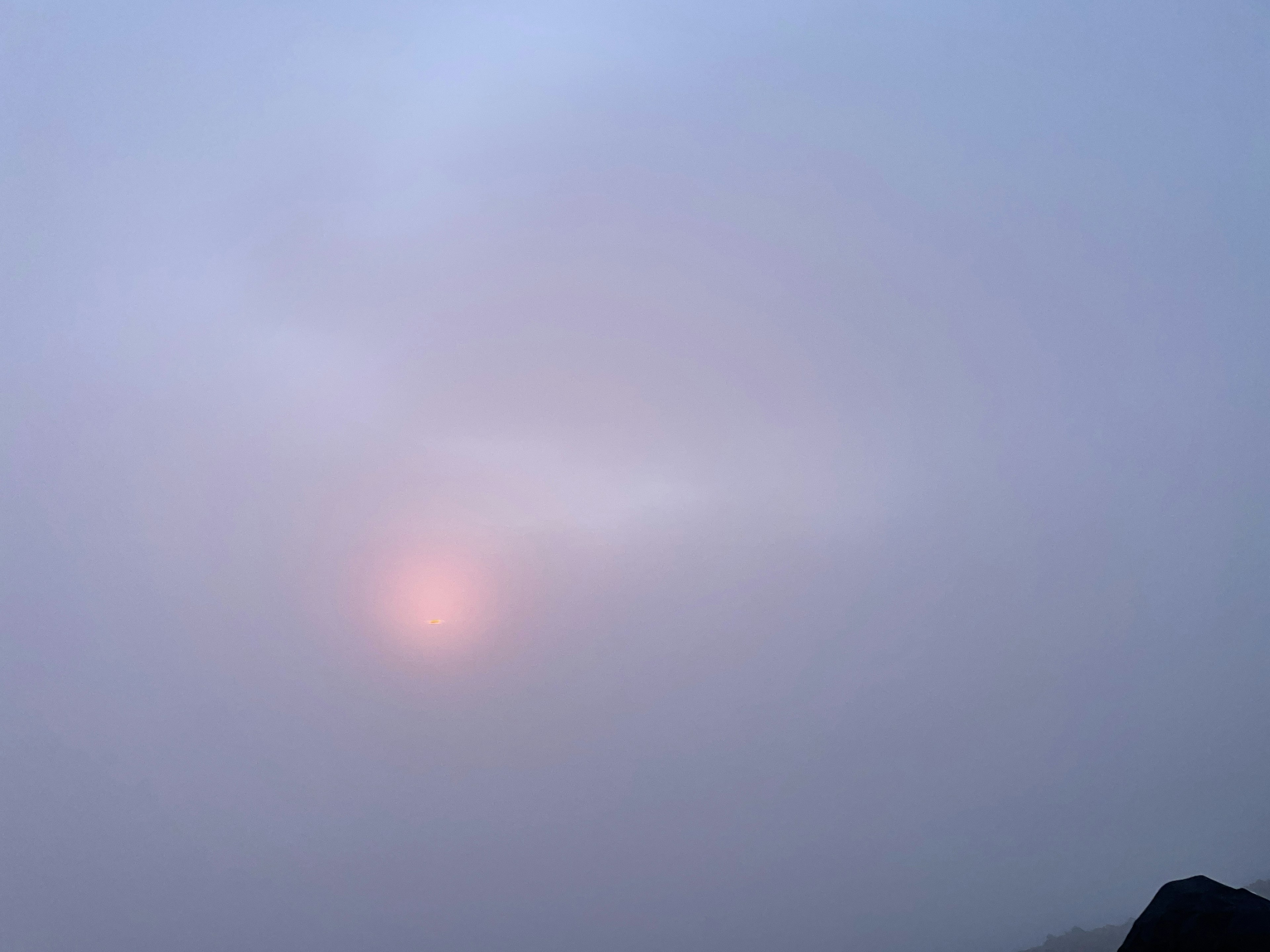 Dim sun visible through a foggy landscape