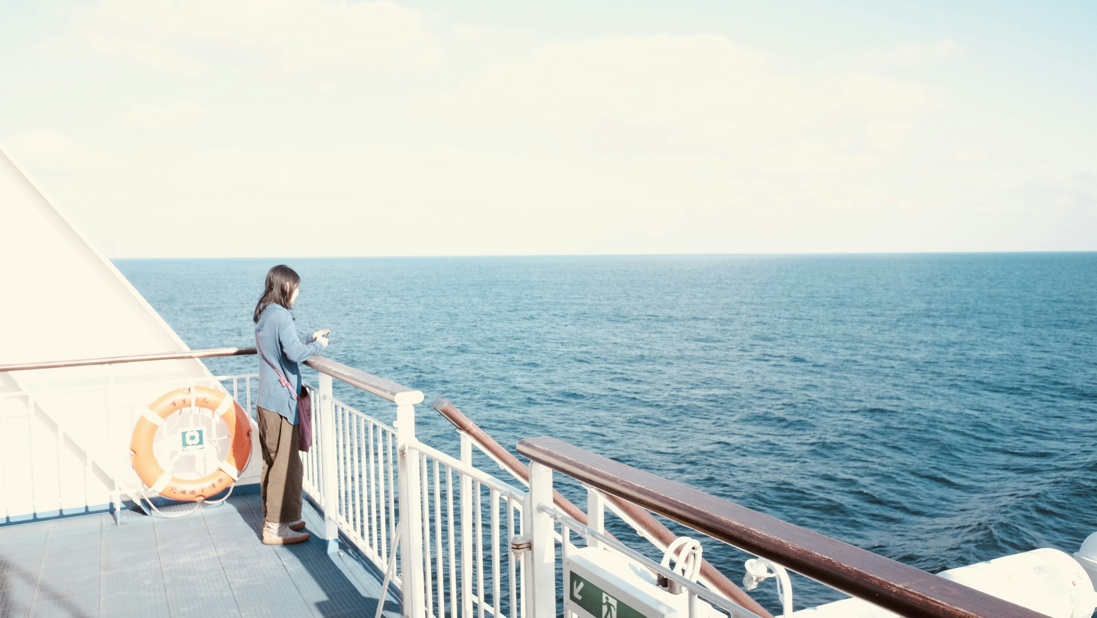 A woman looking out over the ocean from a ship deck