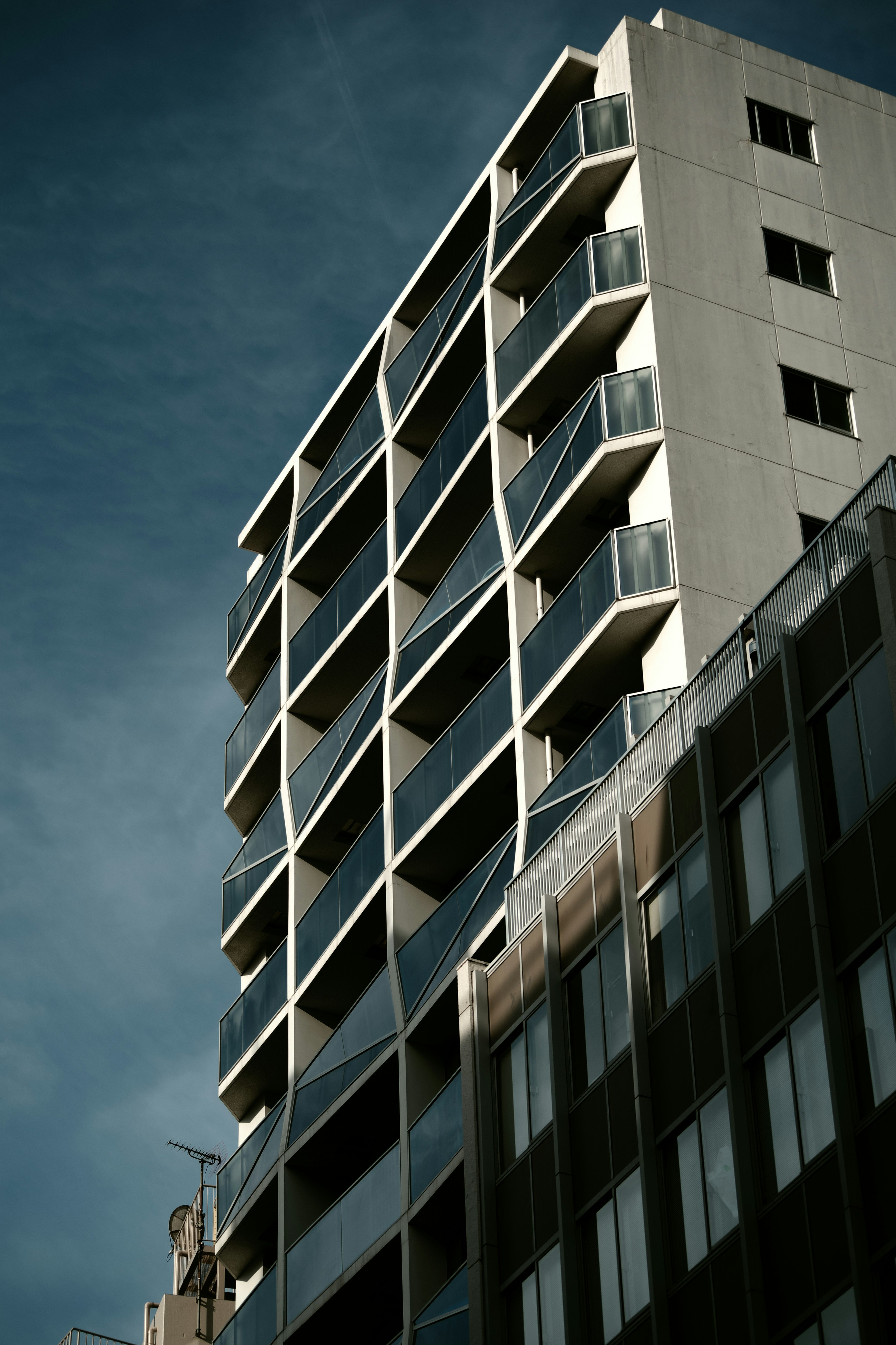 Gedung tinggi modern dengan balkon di bawah langit biru