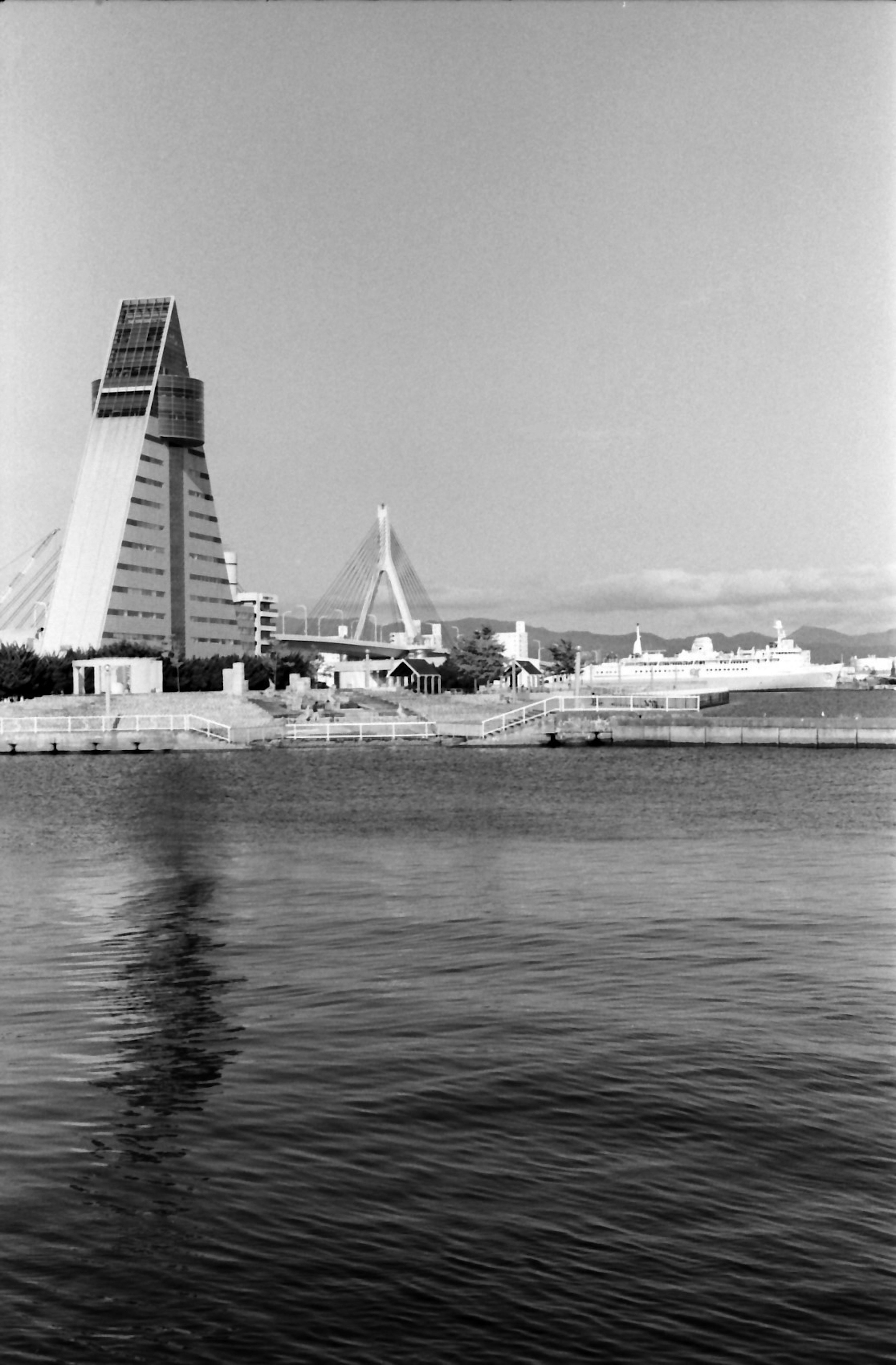 Modern building reflecting in the water with surrounding scenery