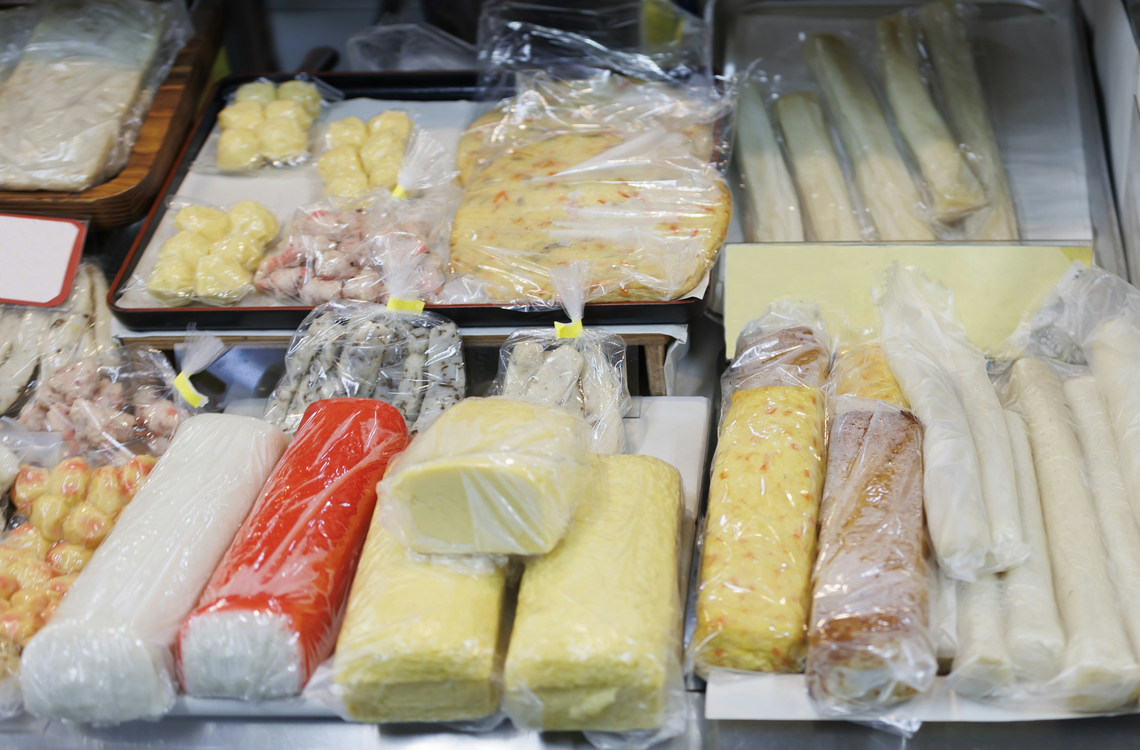 A variety of packaged food items in different colors and shapes displayed in a market