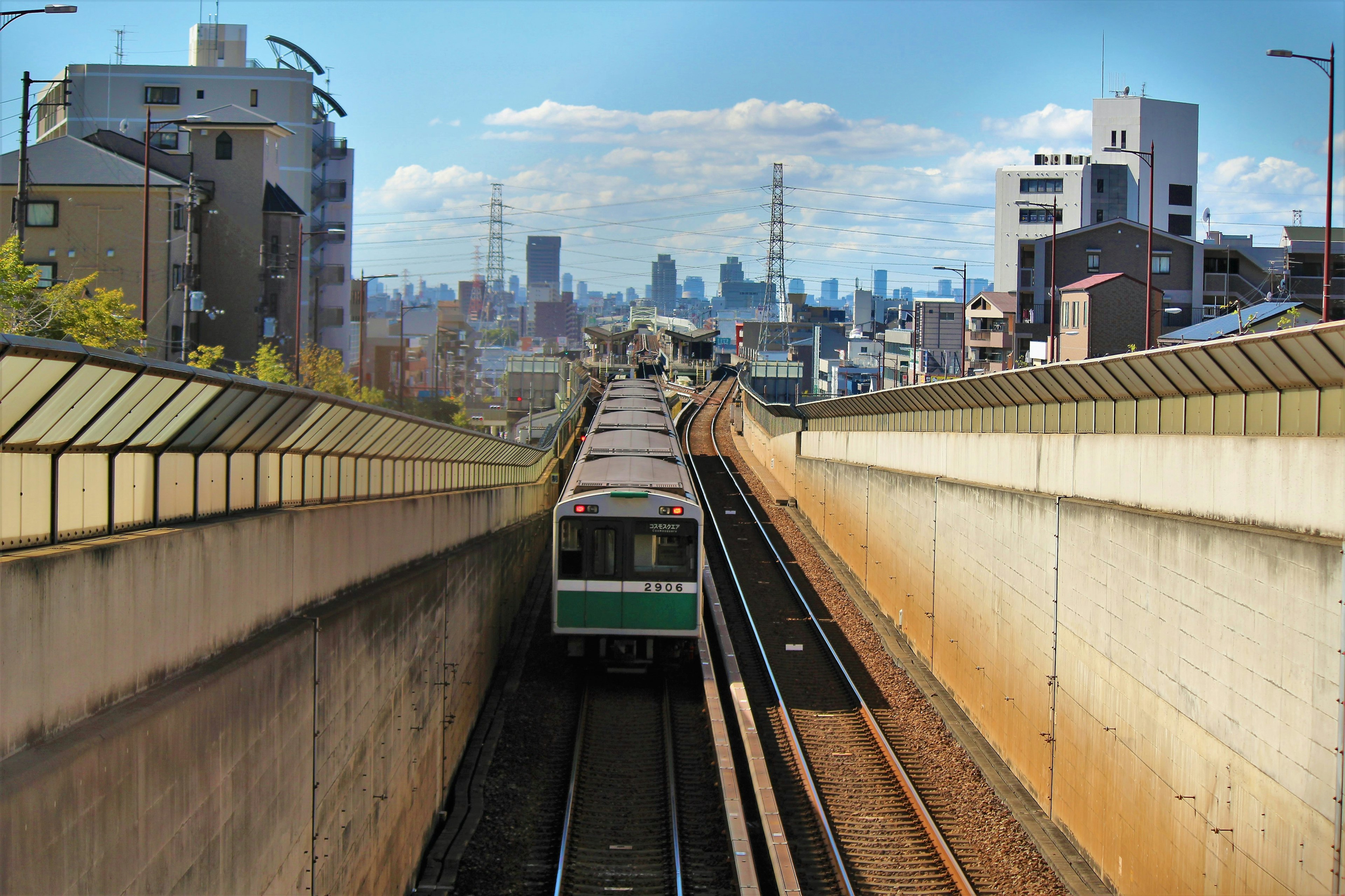 Train running on urban tracks with city skyline in background