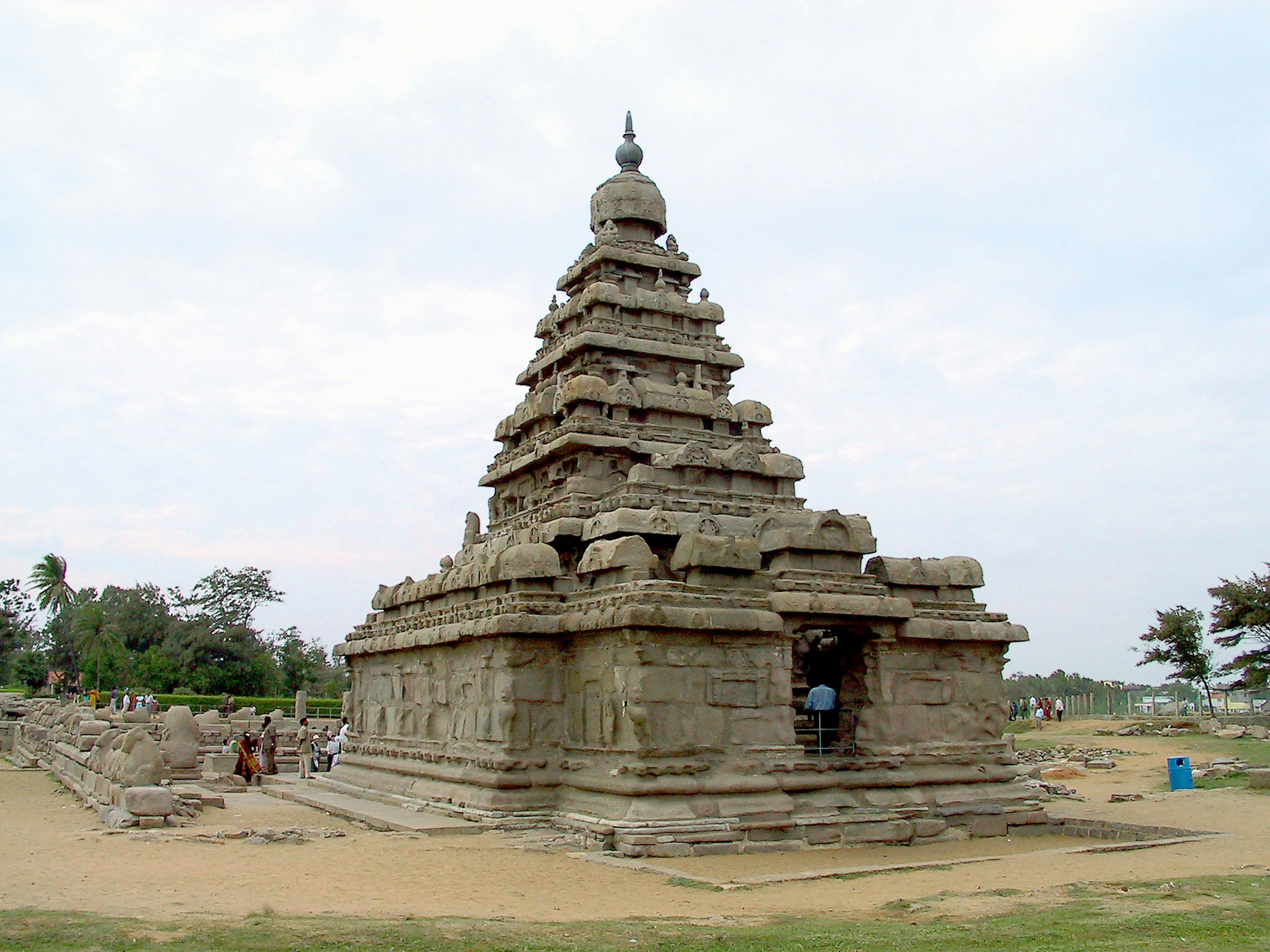 Ancient stone temple exterior with a pyramidal roof and surrounding greenery